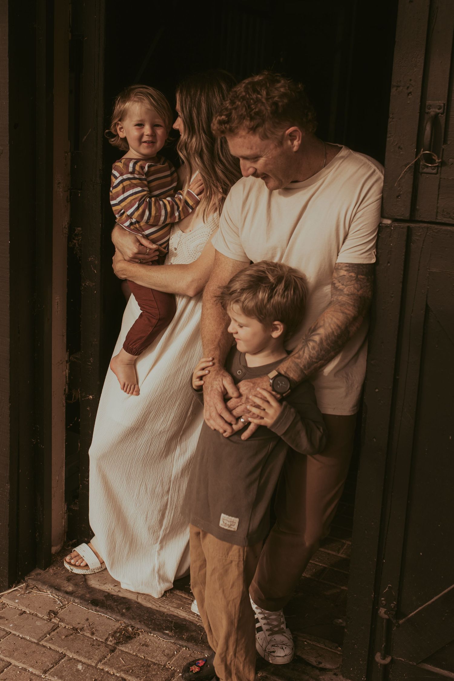 Family standing close together in a doorway during a family session by Durham Region, Ontario