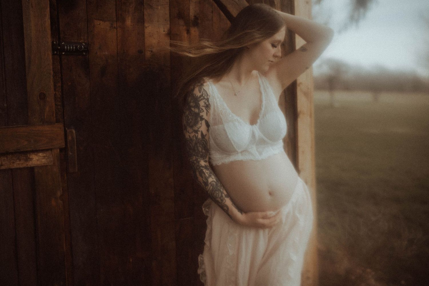 Outdoor maternity session with an expectant mama standing against a barn wall by Bowmanville, ON family photographer.