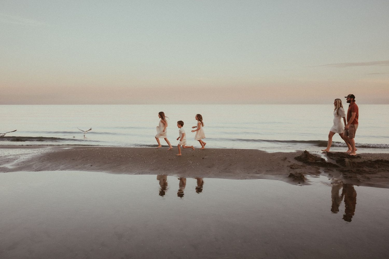 Sunset beach session with a family running and exploring along the shoreline by Bowmanville, ON family photographer.