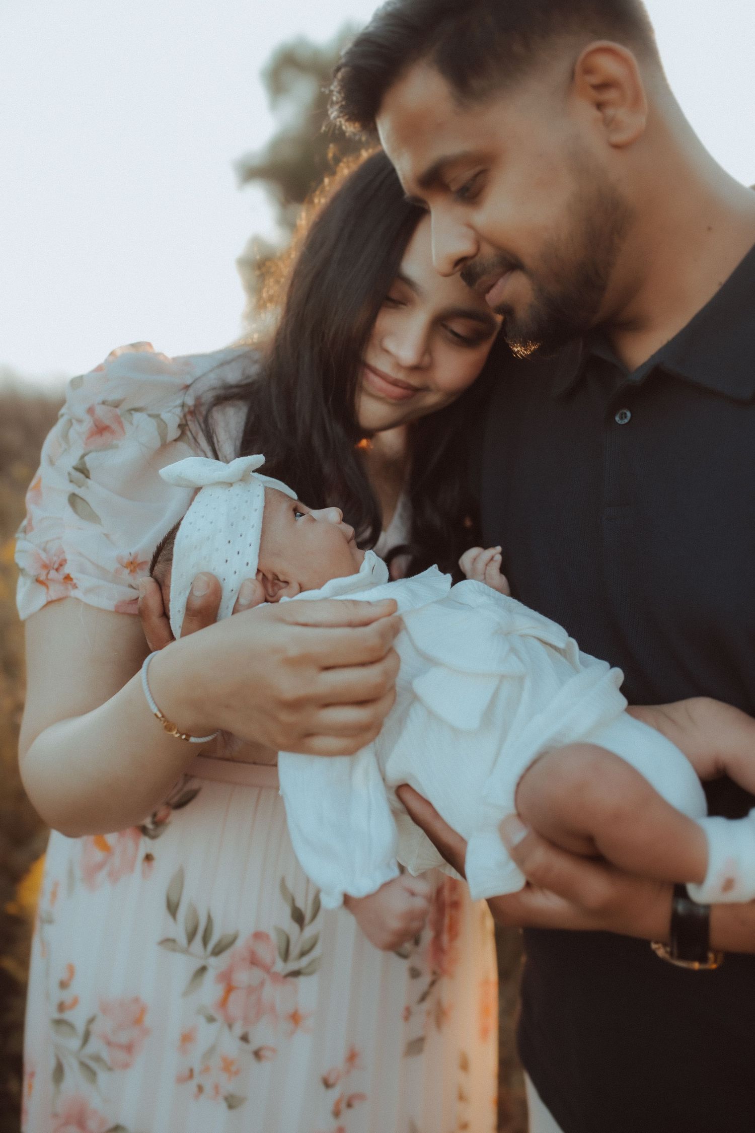 Beach session with a couple holding their newborn baby girl and sharing a sweet moment by Bowmanville, ON family photographer