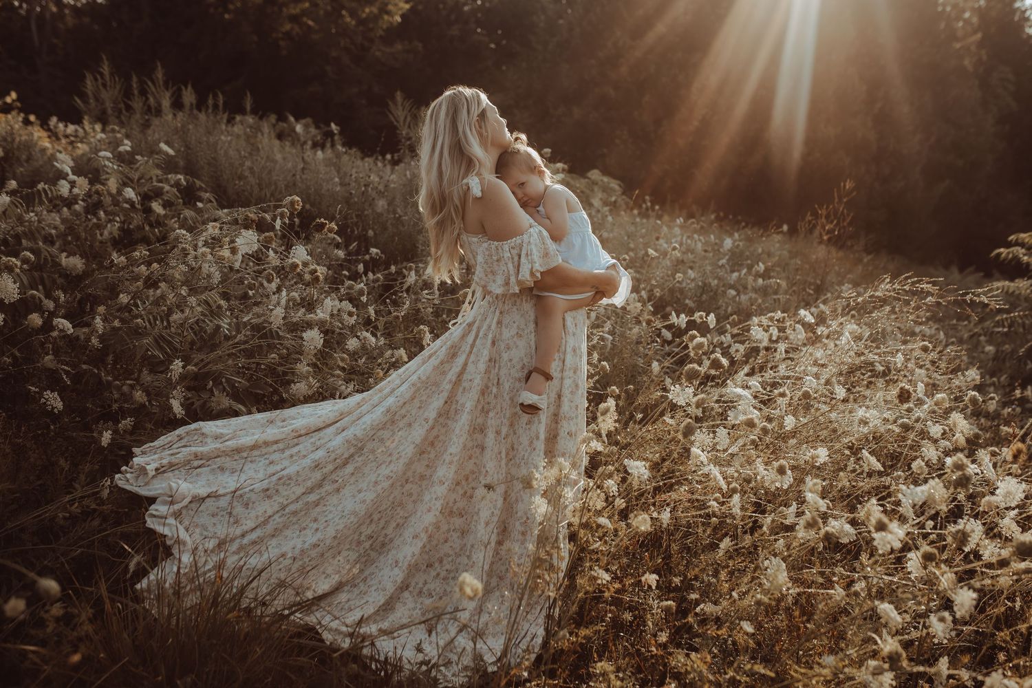 Mother and daughter embracing in a wildflower field during a motherhood photography session in Bowmanville, Ontario