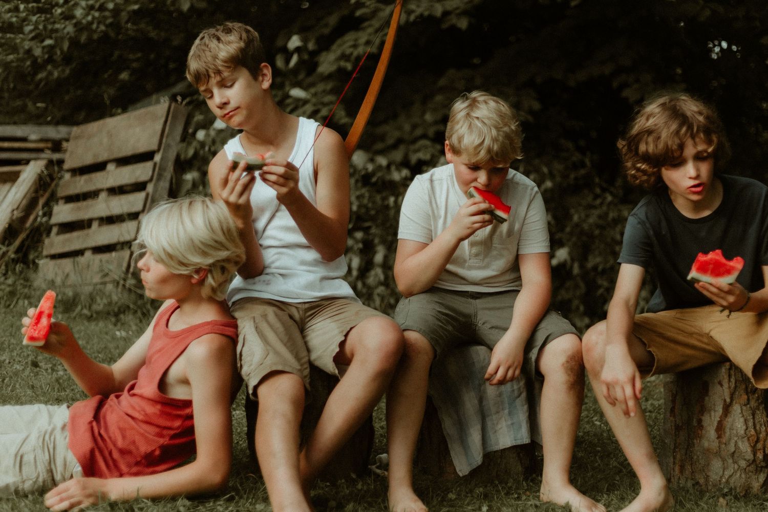 Young teenage boys eating watermelon outdoors on a summer day by Bowmanville, ON family photographer.