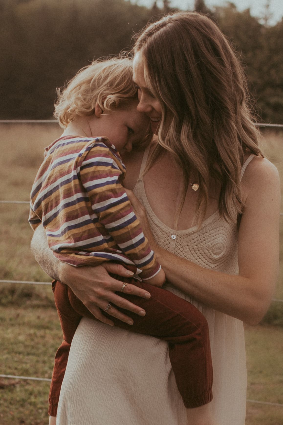 Mother comforting her young son in her arms by Durham Region motherhood photographer