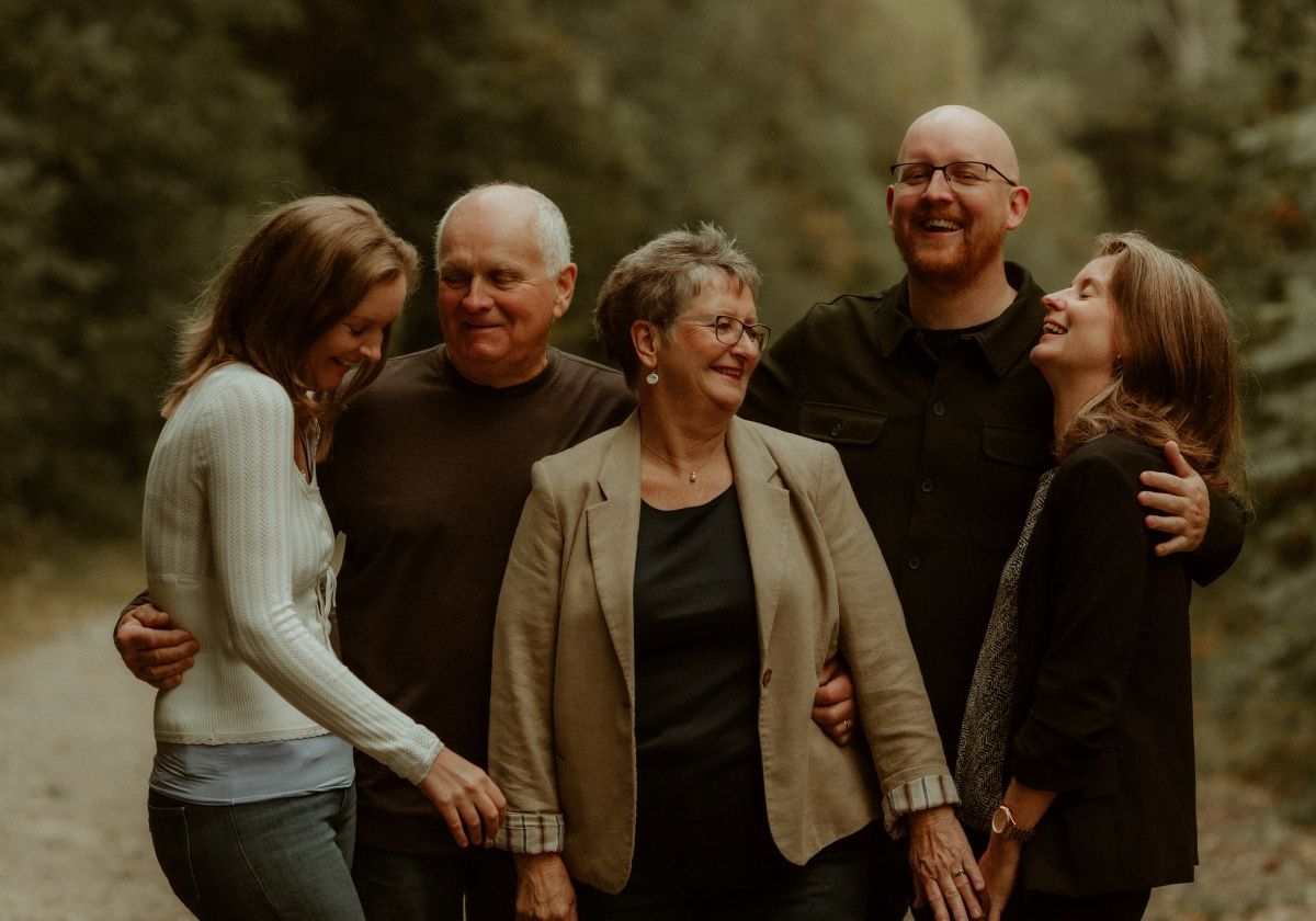 A relaxed and natural family session with parents and adult children talking and laughing candidly.