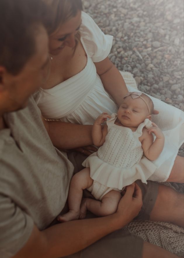 Detail shot of a newborn cradled in her loving parents laps taken by a Bowmanville, ON family photographer.