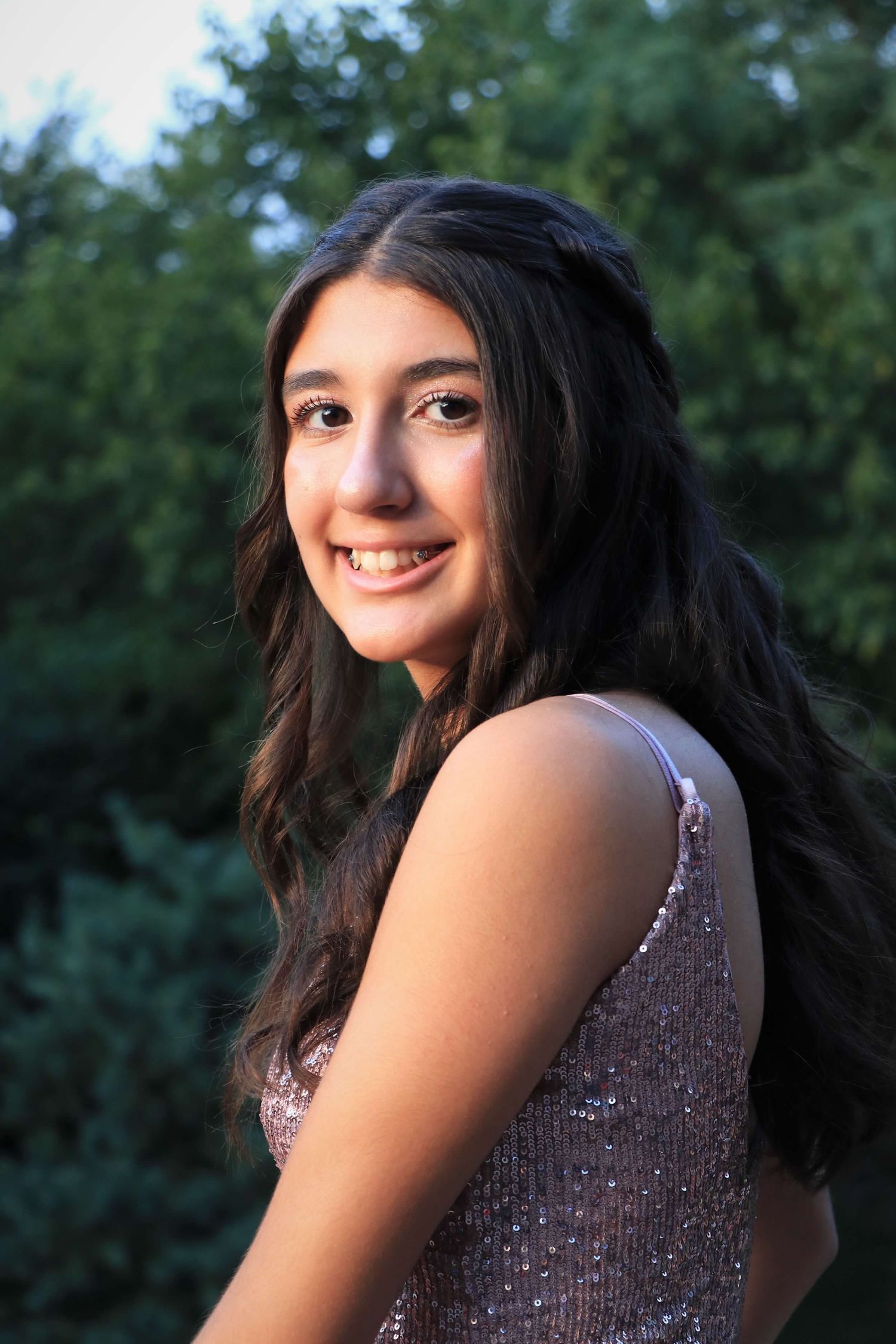 Someone poses for a series of glamour shots outdoors wearing a sparkly purple sequined dress.