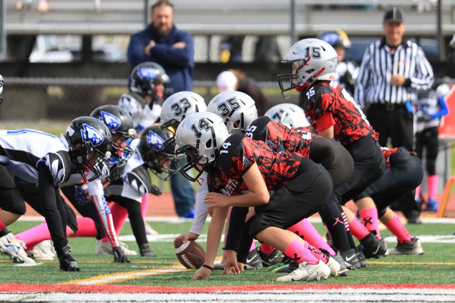 Football players line up at the line of scrimmage during a game.