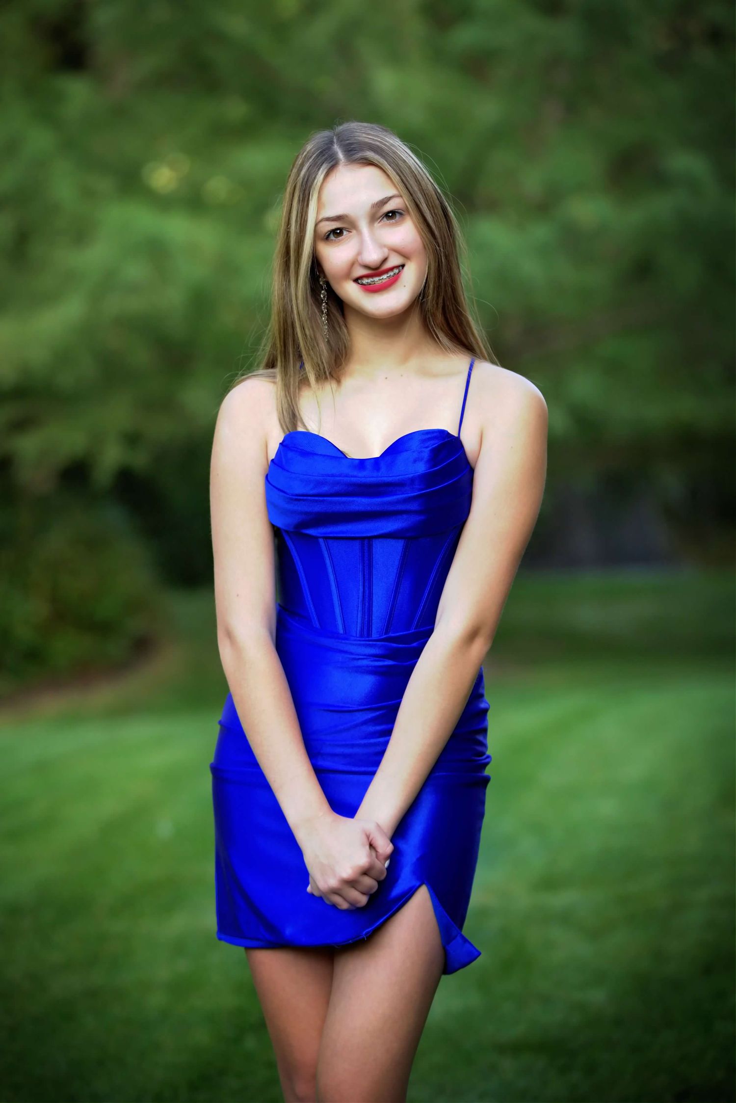 A series of outdoor portrait photos showing someone in a vibrant royal blue dress against a lush green natural backdrop.