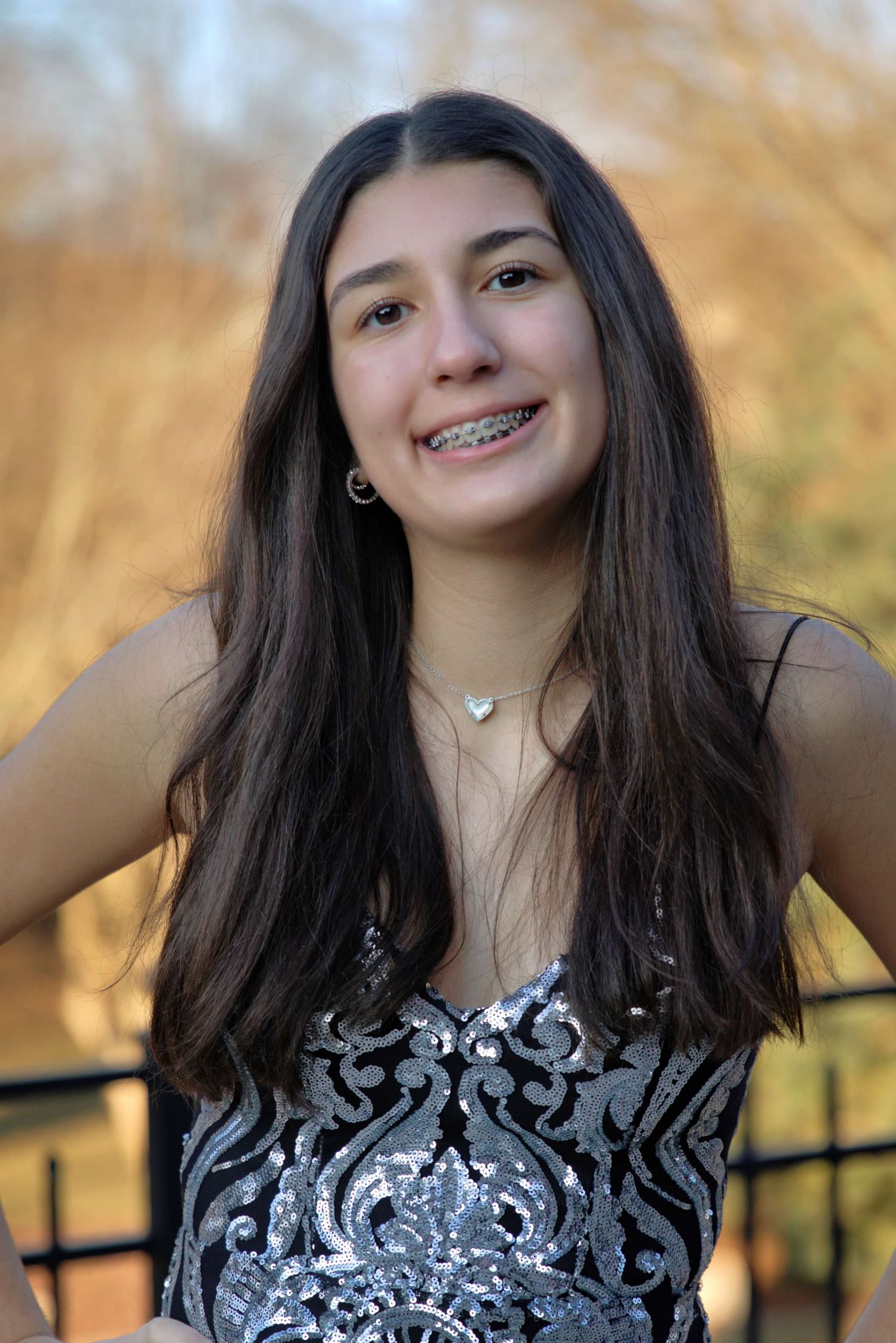 A series of photos showing someone in a black and white patterned dress with a delicate necklace.