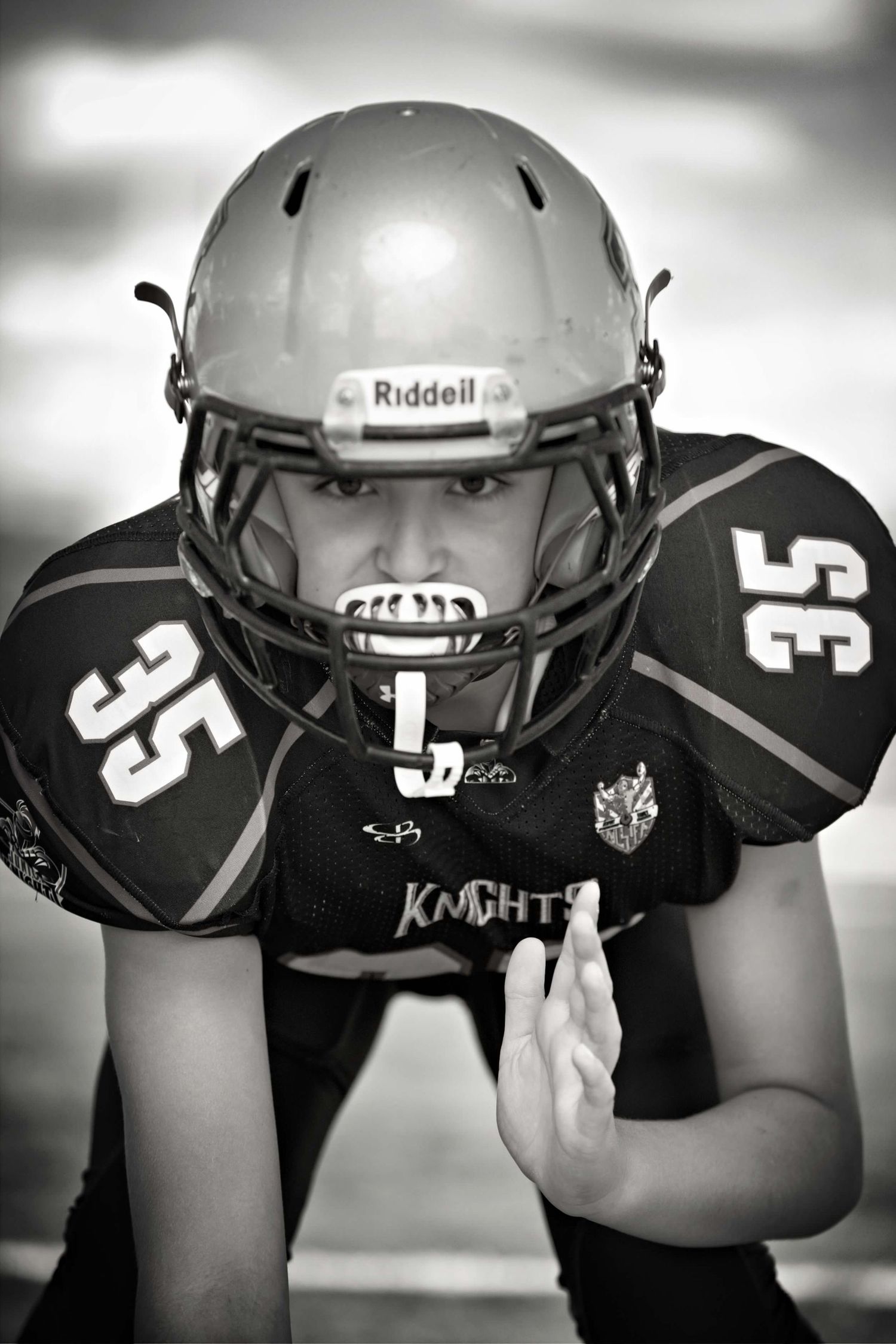 Black and white artistic photo collage of football helmets arranged in a horizontal row.