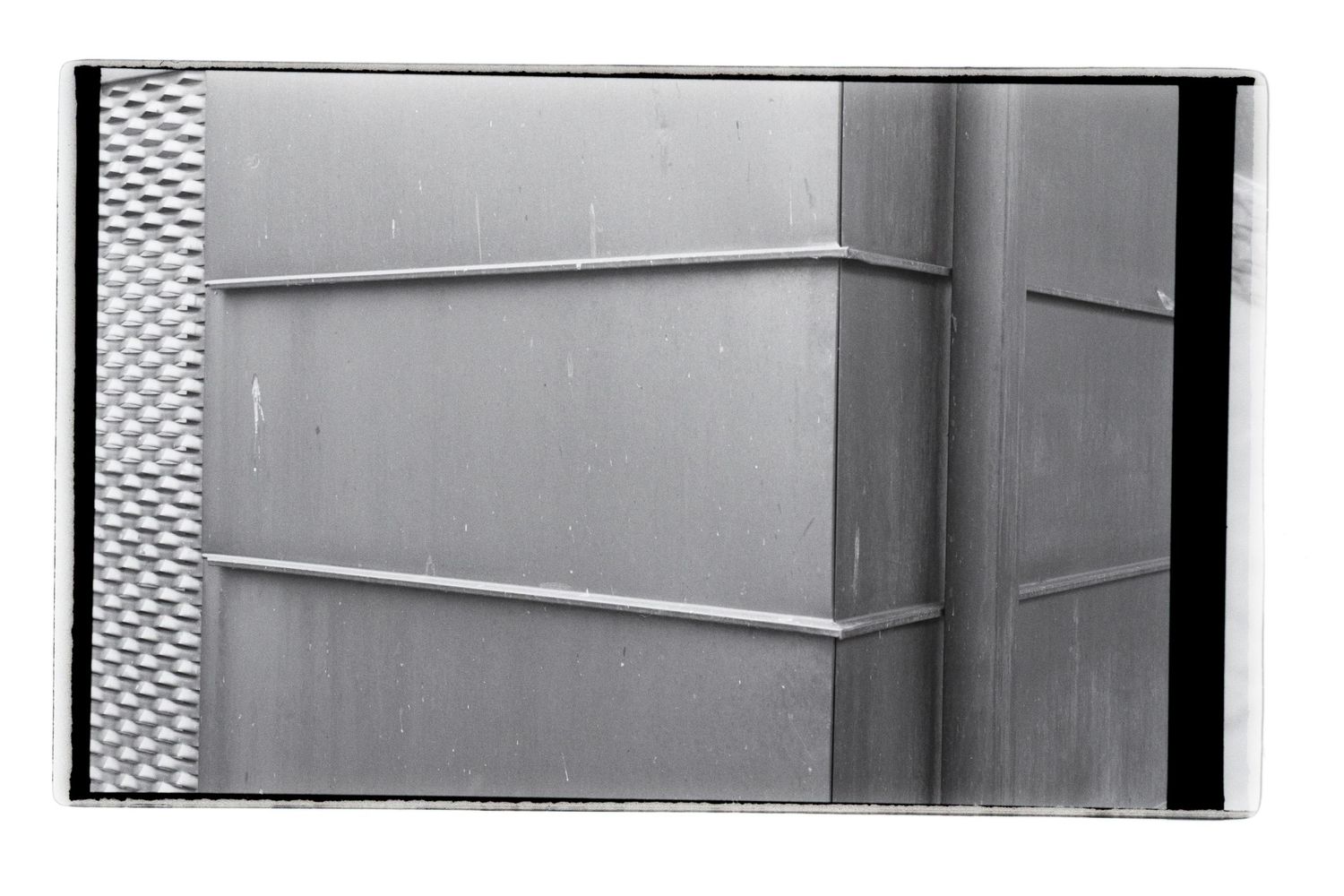 Abstract black and white photo of a wall with different shapes and leading lines.