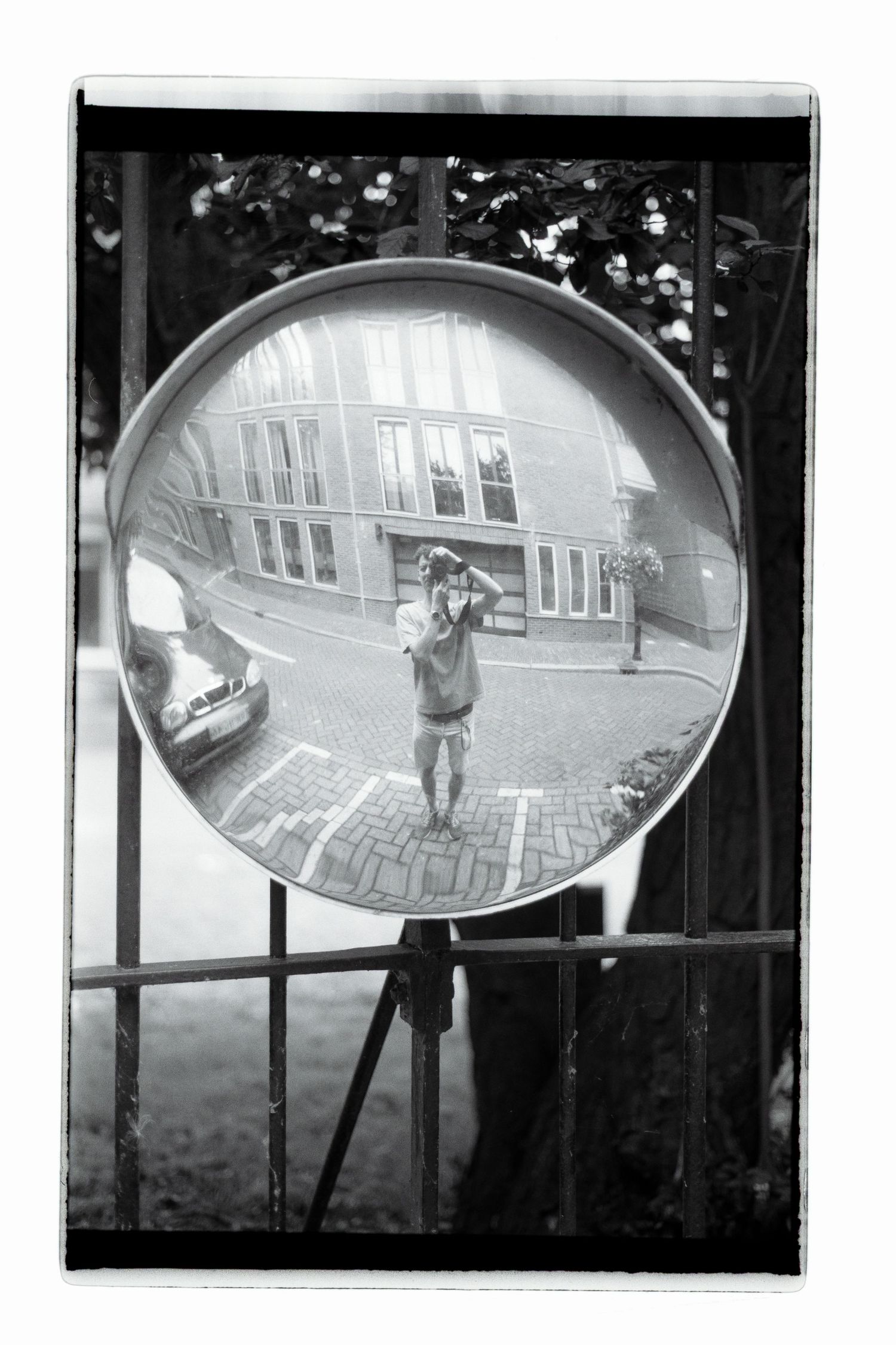 Black and white shot of the photographer in a roadside mirror.