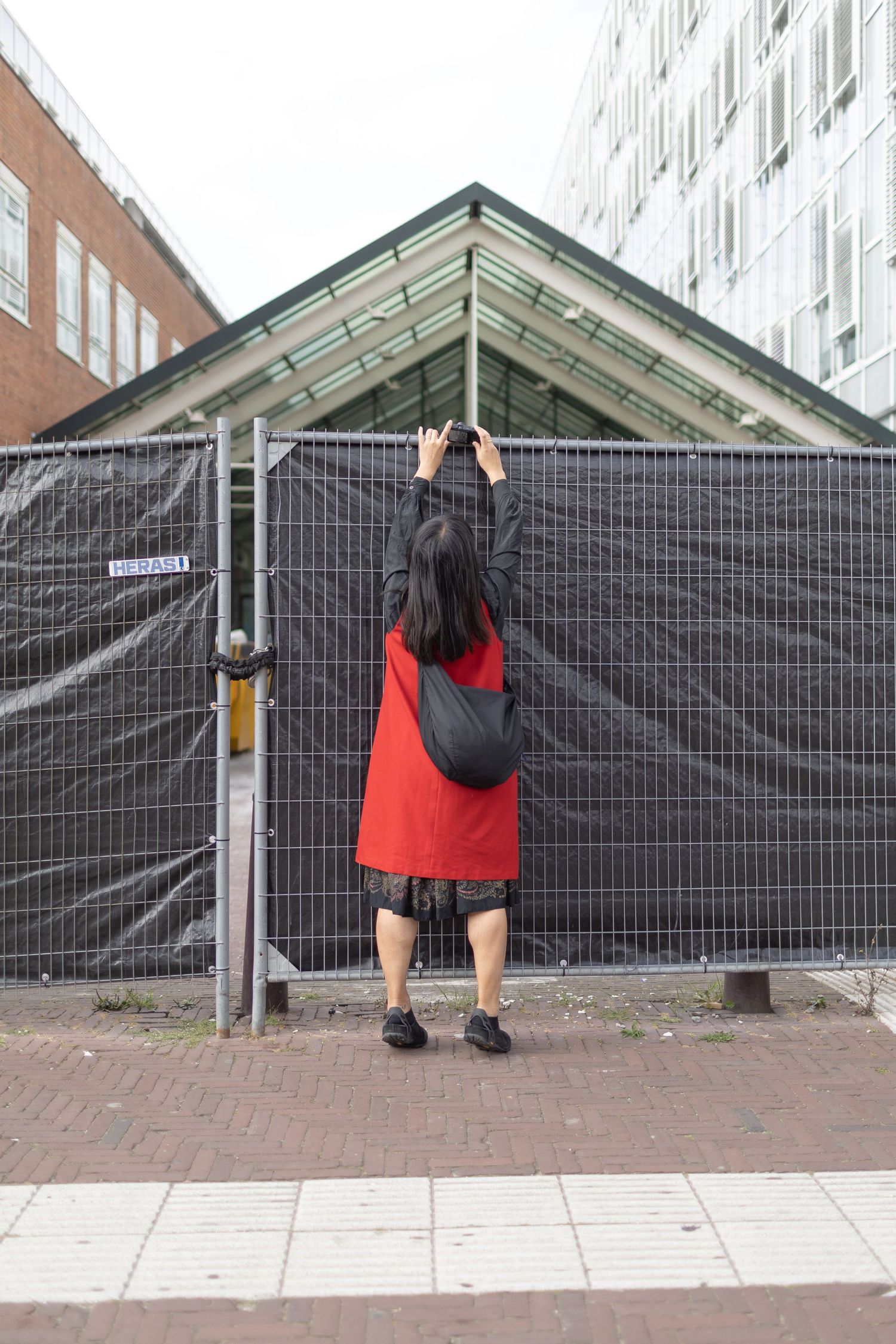One of Process' participants photographer from behind, shooting over a fence while tiptoeing.