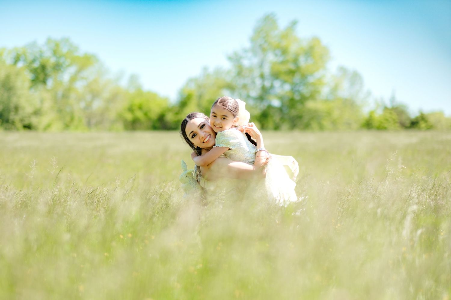 A loving embrace shared between two people in a sunlit meadow of tall grass on a bright summer day.