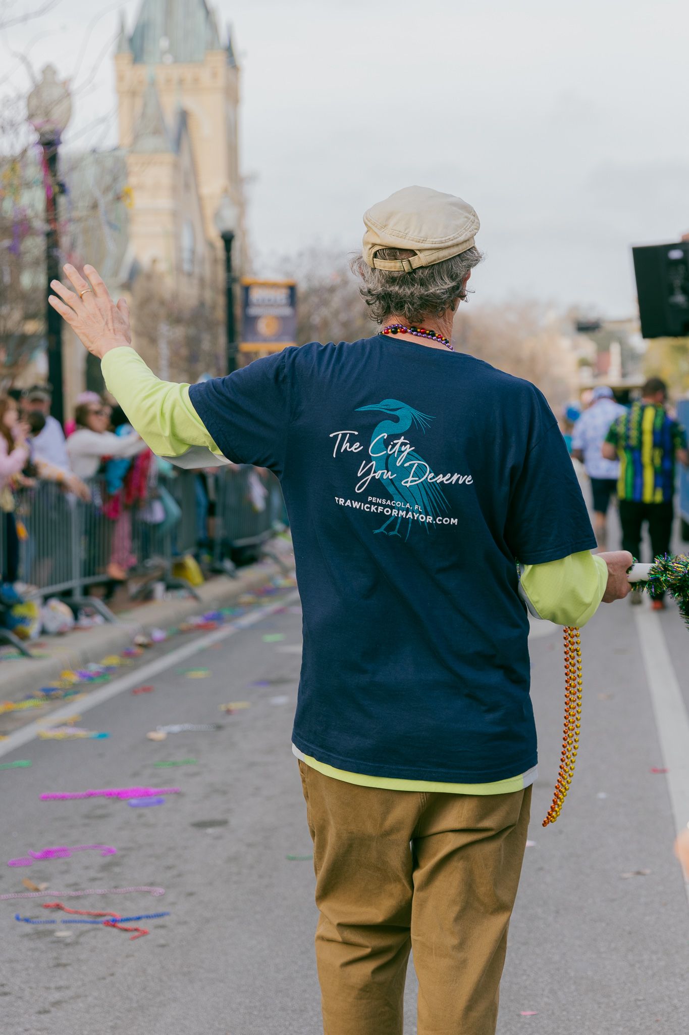 Person wearing a navy blue t-shirt with 'The Dream' text walking down a street with confetti on the ground.