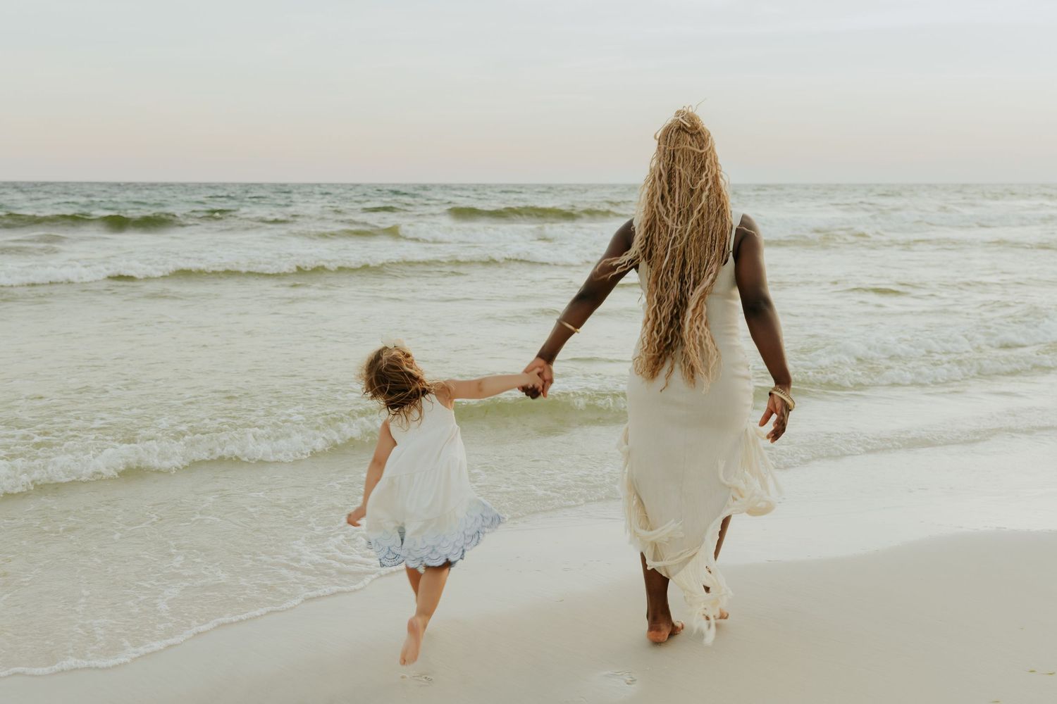 A sequence of beach photos shows a parent and child walking hand in hand along the shoreline at sunset.