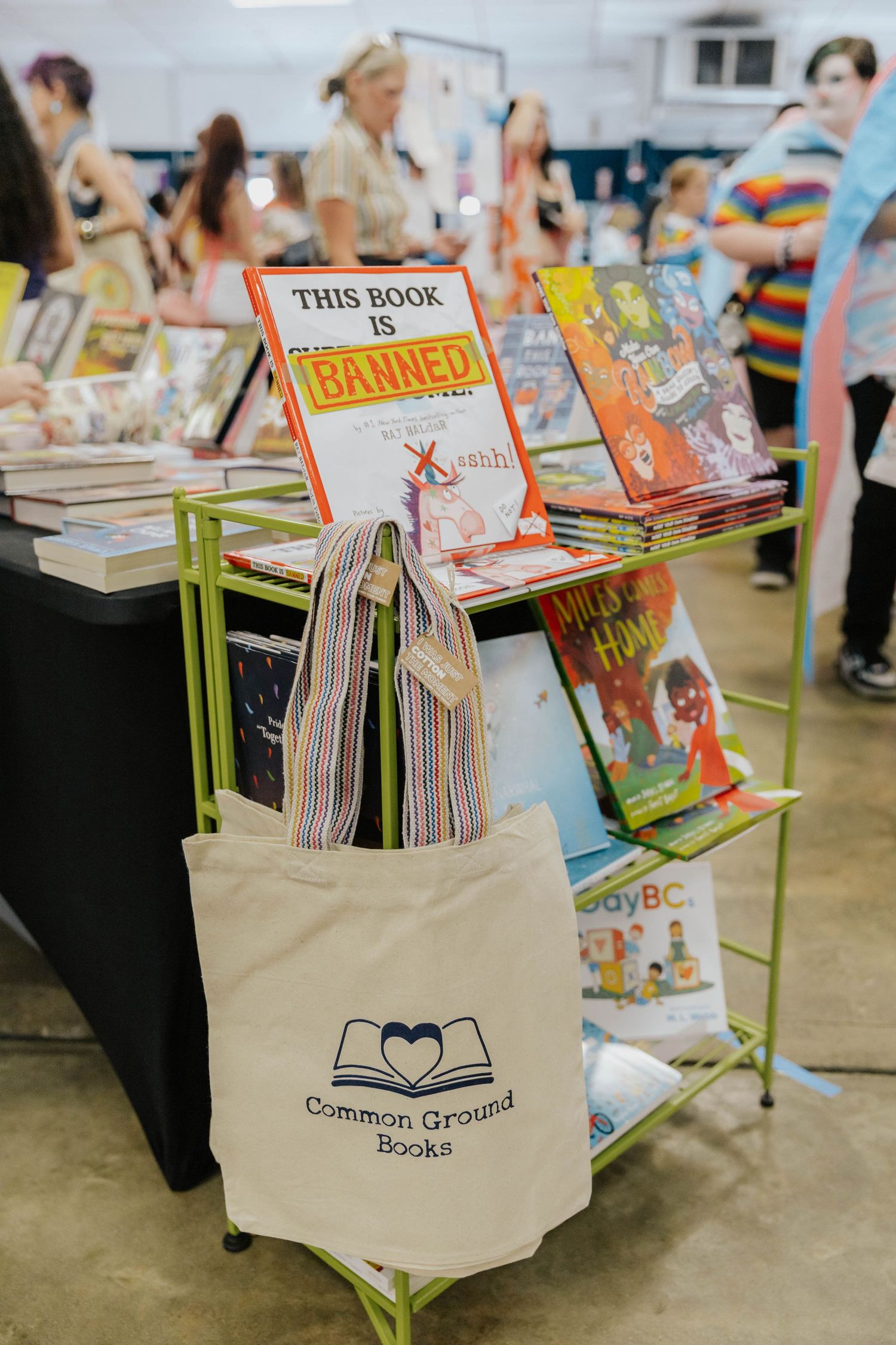 Canvas tote bags filled with books sit on display at Common Ground Books indie bookstore event.