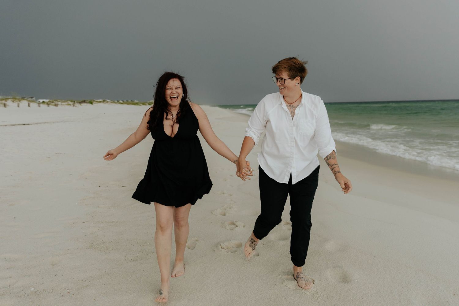 Couple running and playing together along a misty beachfront.