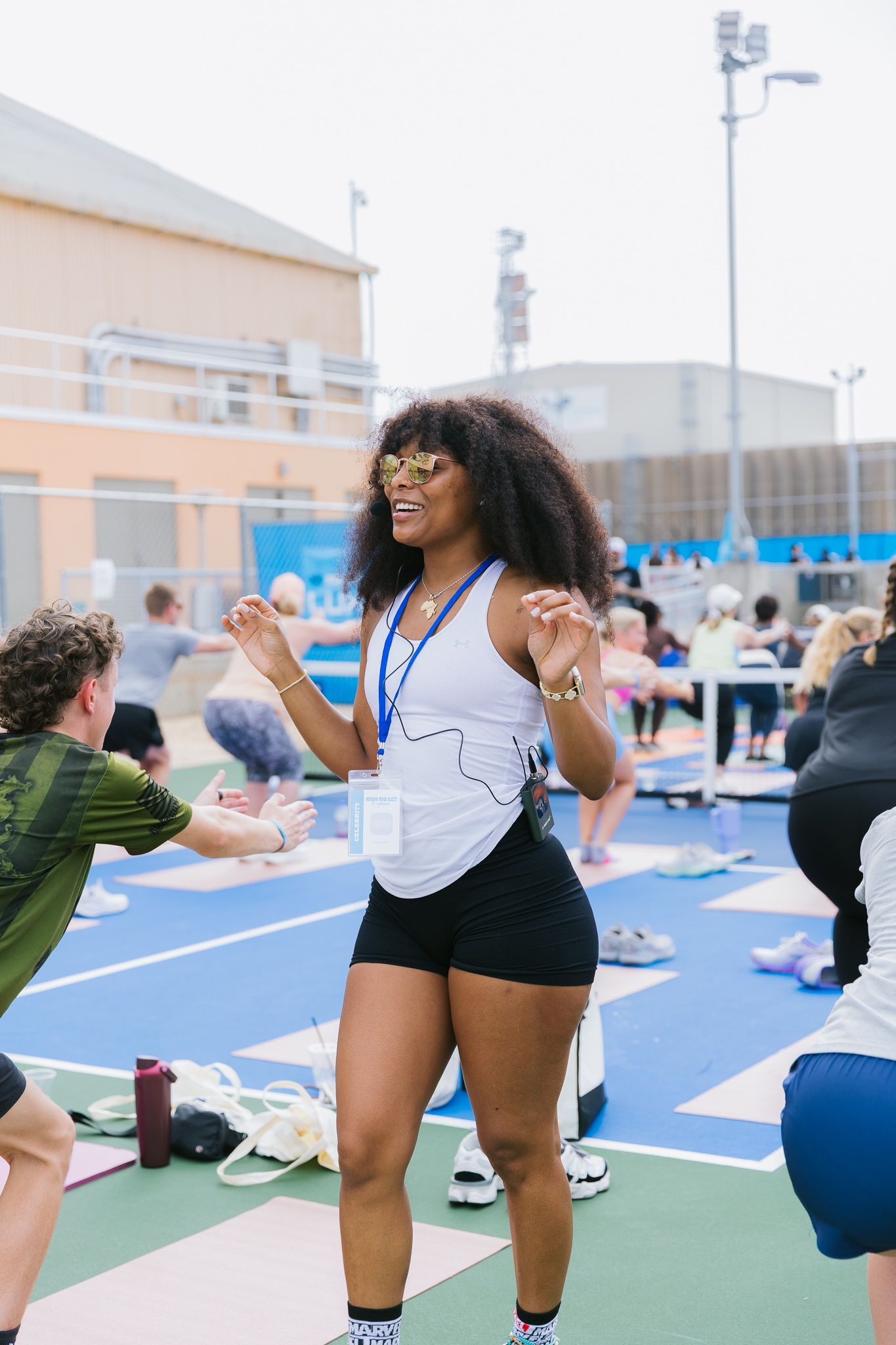 Group of people exercising together on blue yoga mats during an outdoor fitness class.