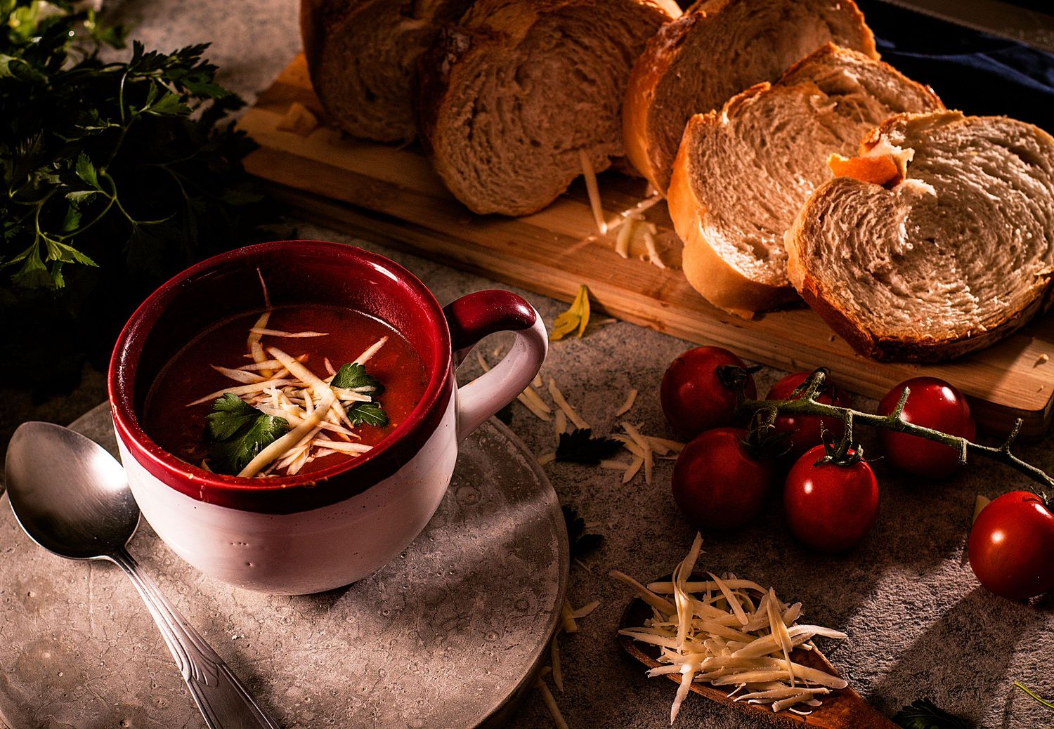 Sopa de tomate com queijo ralado e salsa, servida com fatias de pão artesanal. Conforto e sabor em um clique.