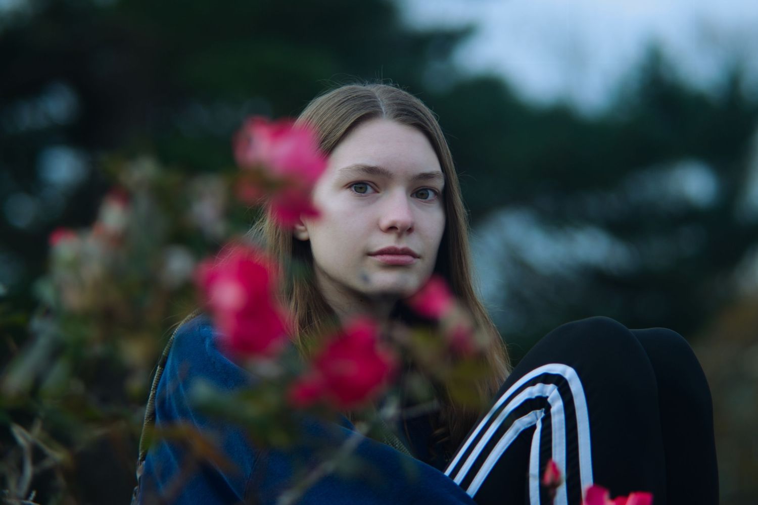 Sister behind red flowers