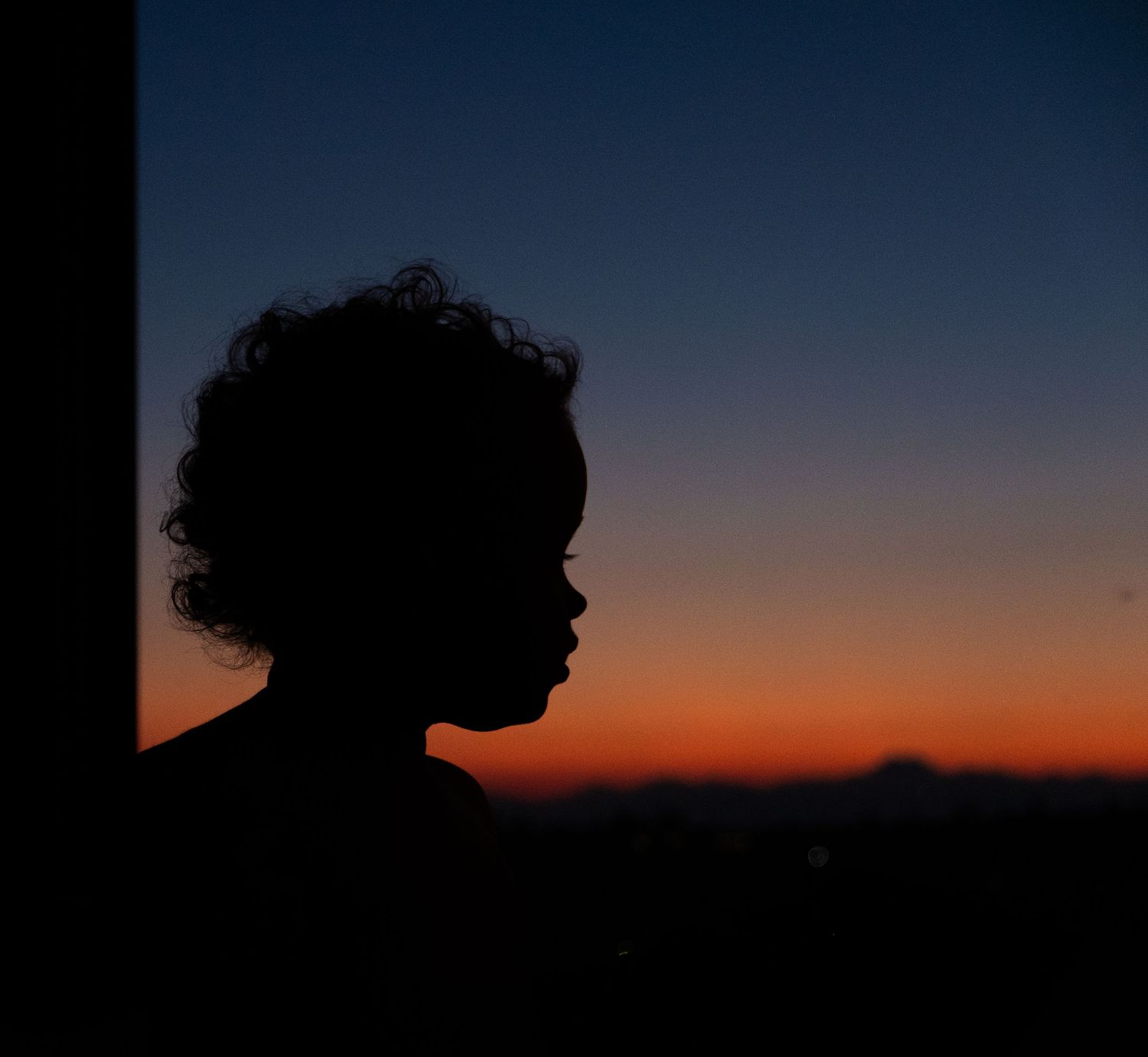 Silhouette profile against dramatic sunset sky.