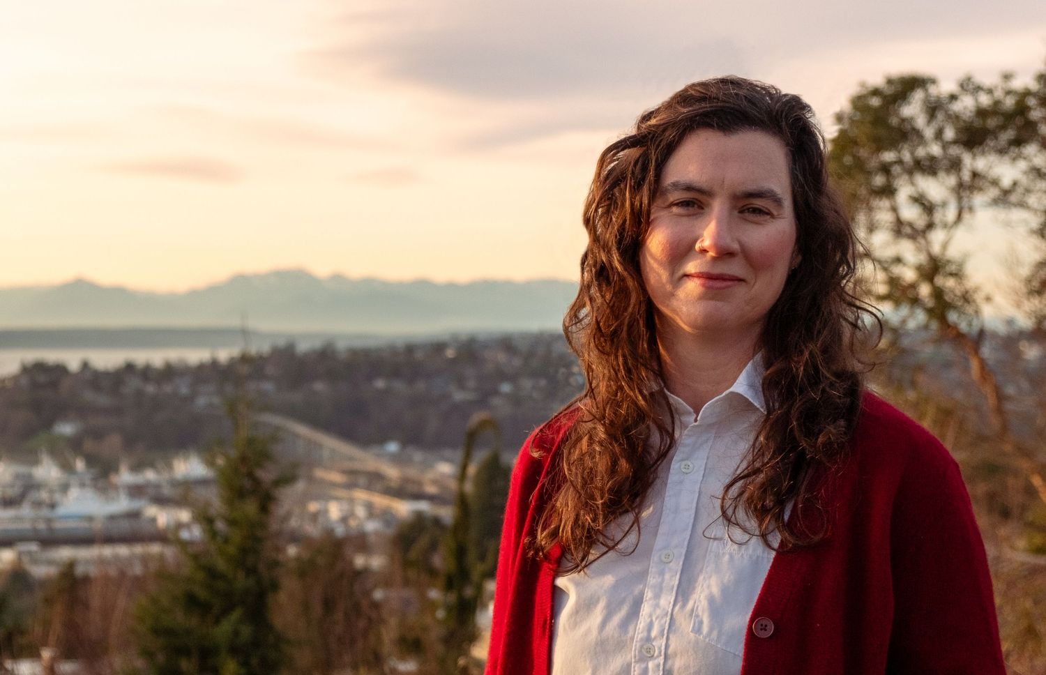 Portrait against sunset with mountains in background.