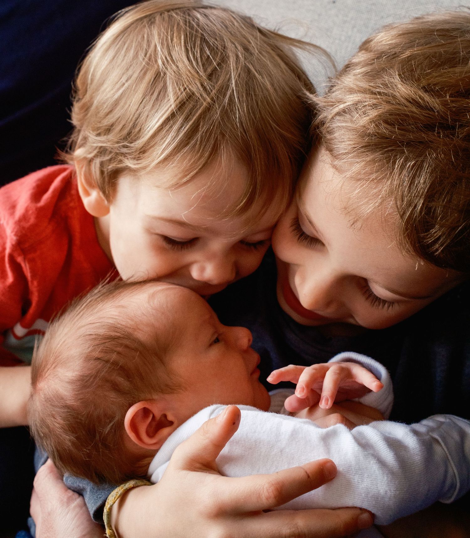 Children in red shirts sharing affectionate moments in a sequence of close-up photos.