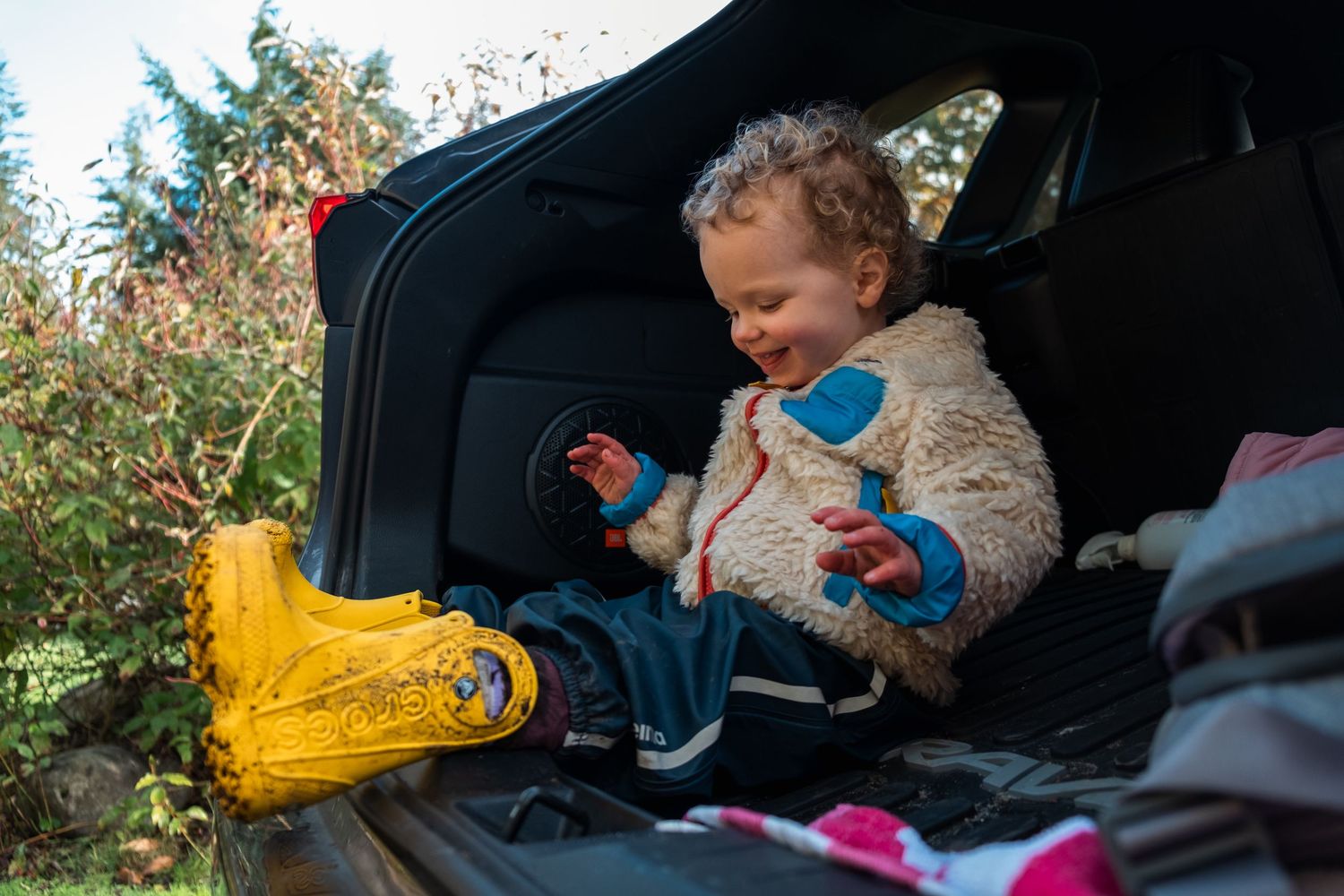 A sequence of images showing a child playing in a car seat with toys.