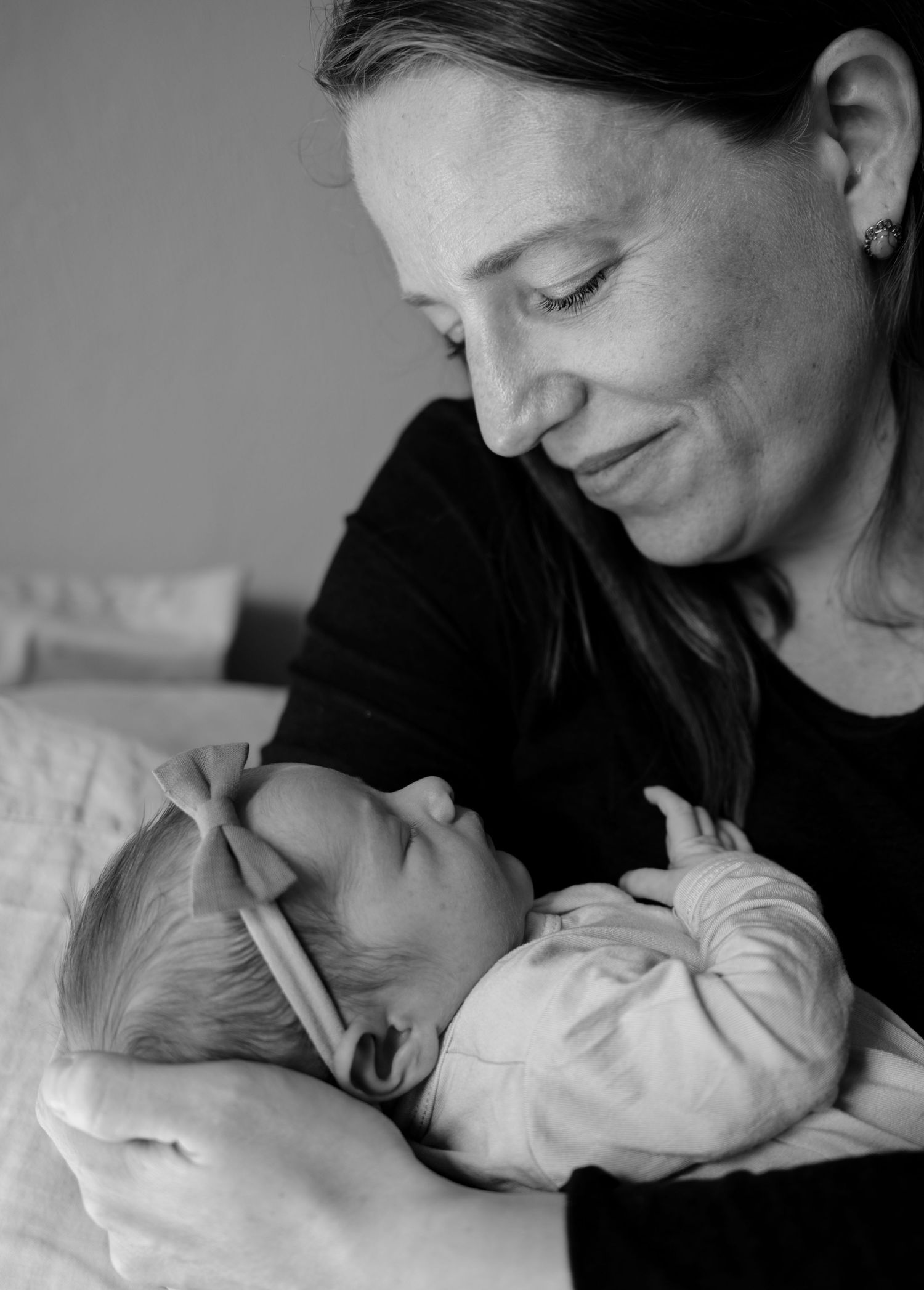 Black and white portrait series showing tender moments between parent and infant in intimate close-ups.