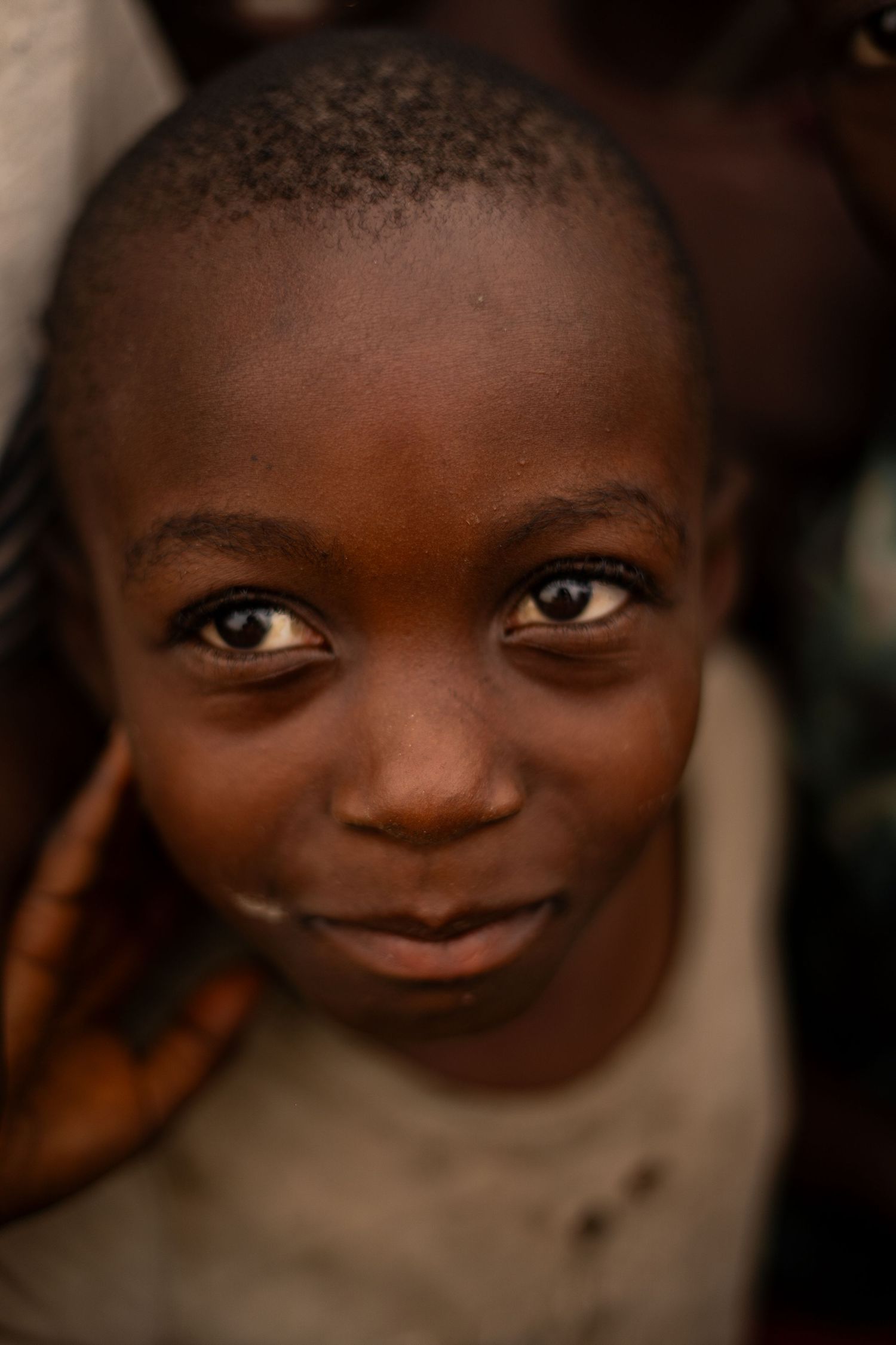 Close-up black and white portrait showing bright eyes and warm smile.