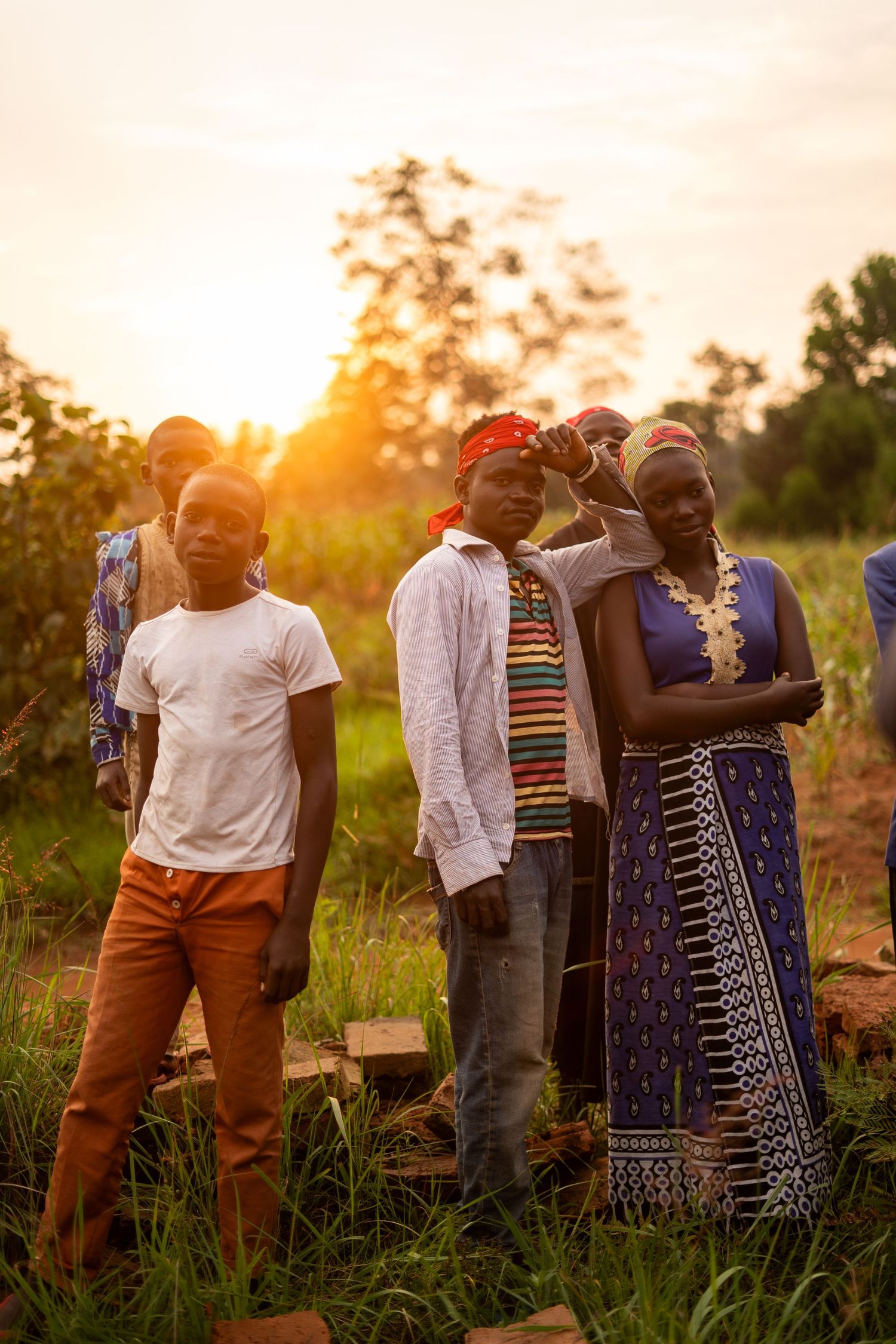 Group gathering outdoors during sunset with colorful clothing and American flag decorations.