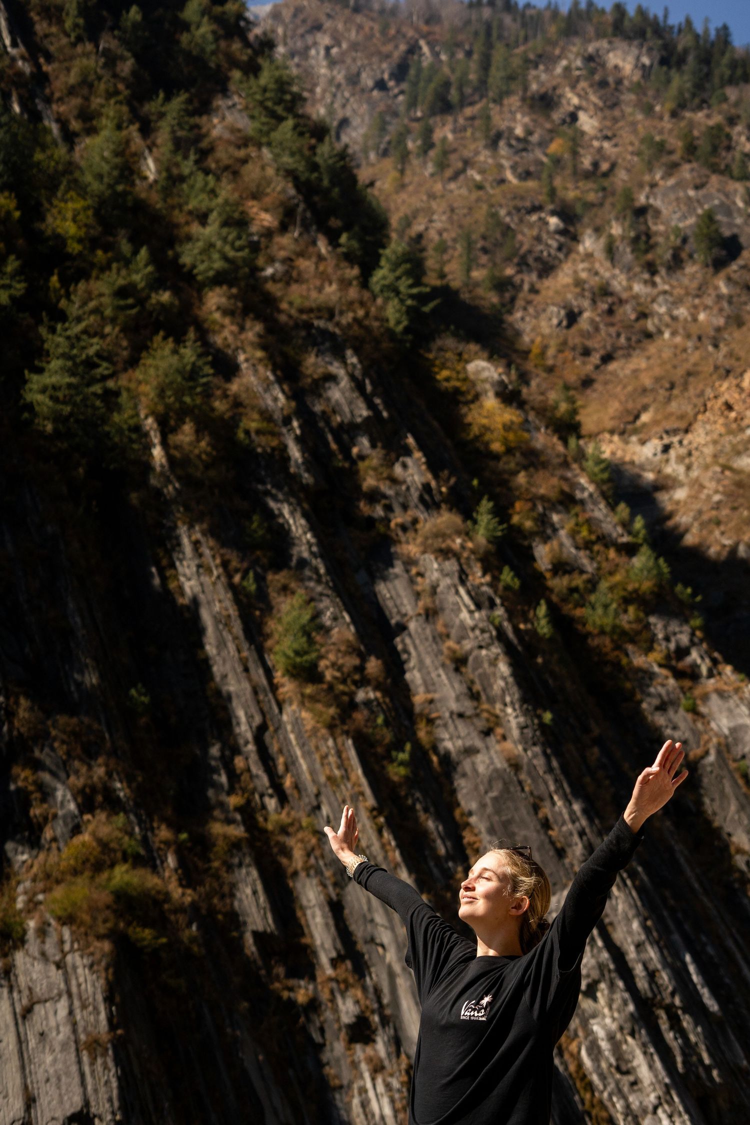 A joyful moment captured against dramatic rocky cliffs in mountain terrain.