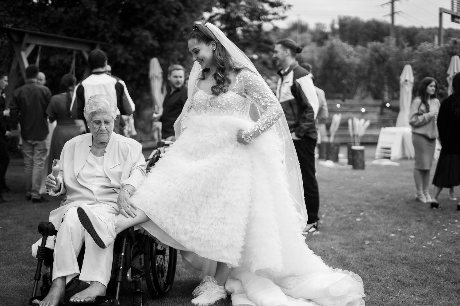 Sweet celebration moment during outdoor wedding reception with wheelchair guest.