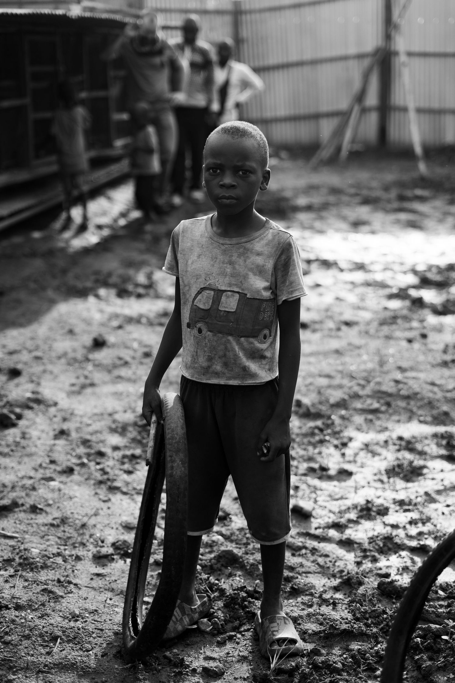 Black and white photos showing a child using handmade crutches in a muddy outdoor setting.