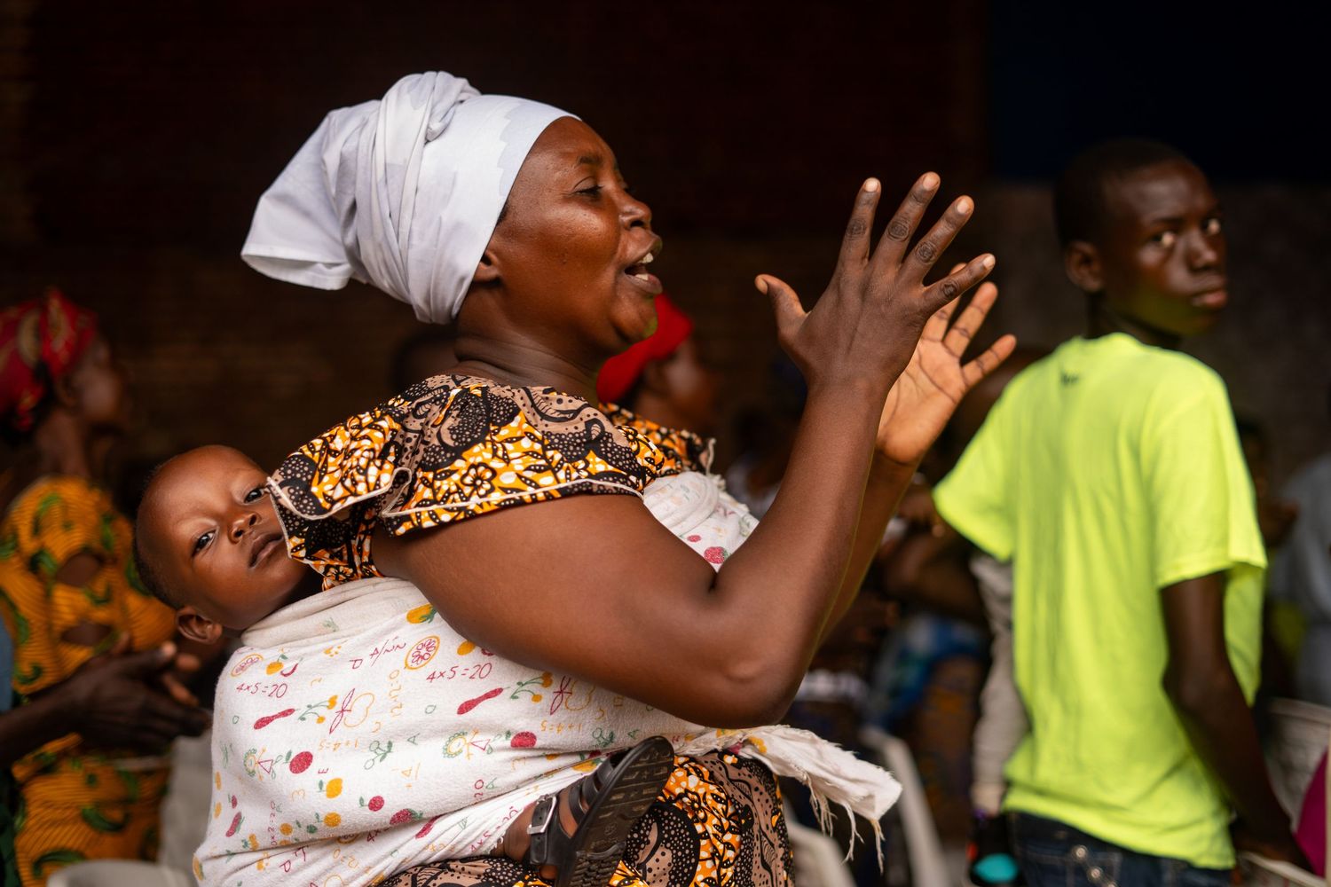 People engaged in joyful dancing and celebration indoors wearing traditional dress.