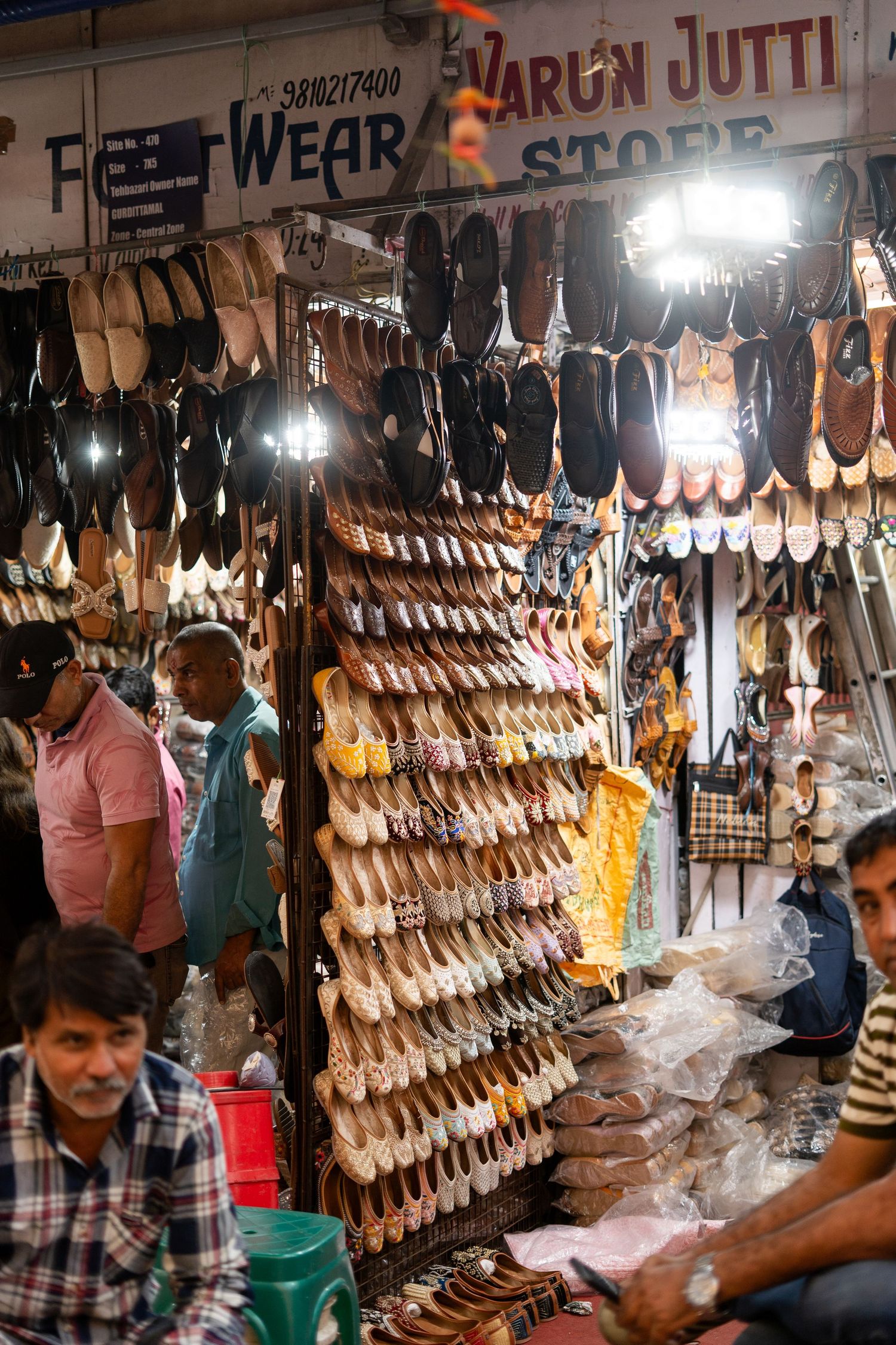 A row of handmade leather shoes and sandals on display at a market stall.