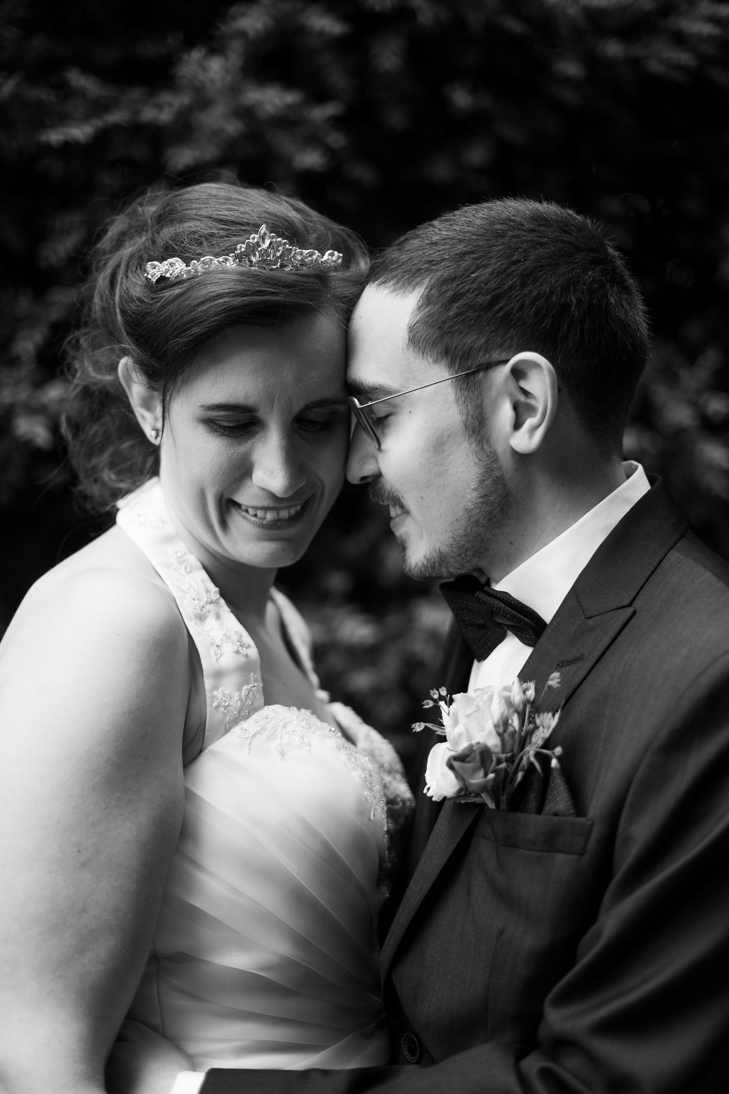 Intimate black and white wedding portraits showing tender moments between couple in formal attire.