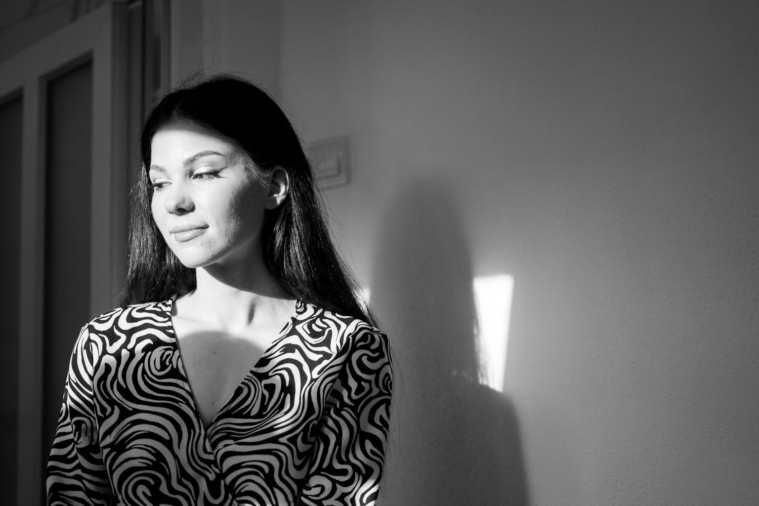A stylish portrait in black and white featuring someone in a zebra print dress.