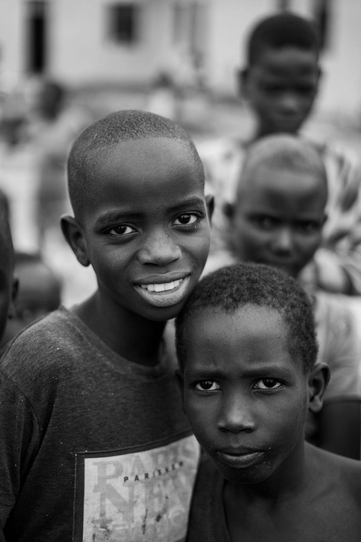 Group of young children in black and white photo looking at camera with bright expressions.