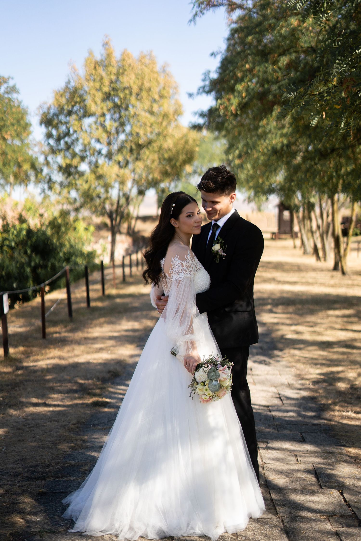 A series of romantic wedding portraits captured in a sunlit garden pathway.