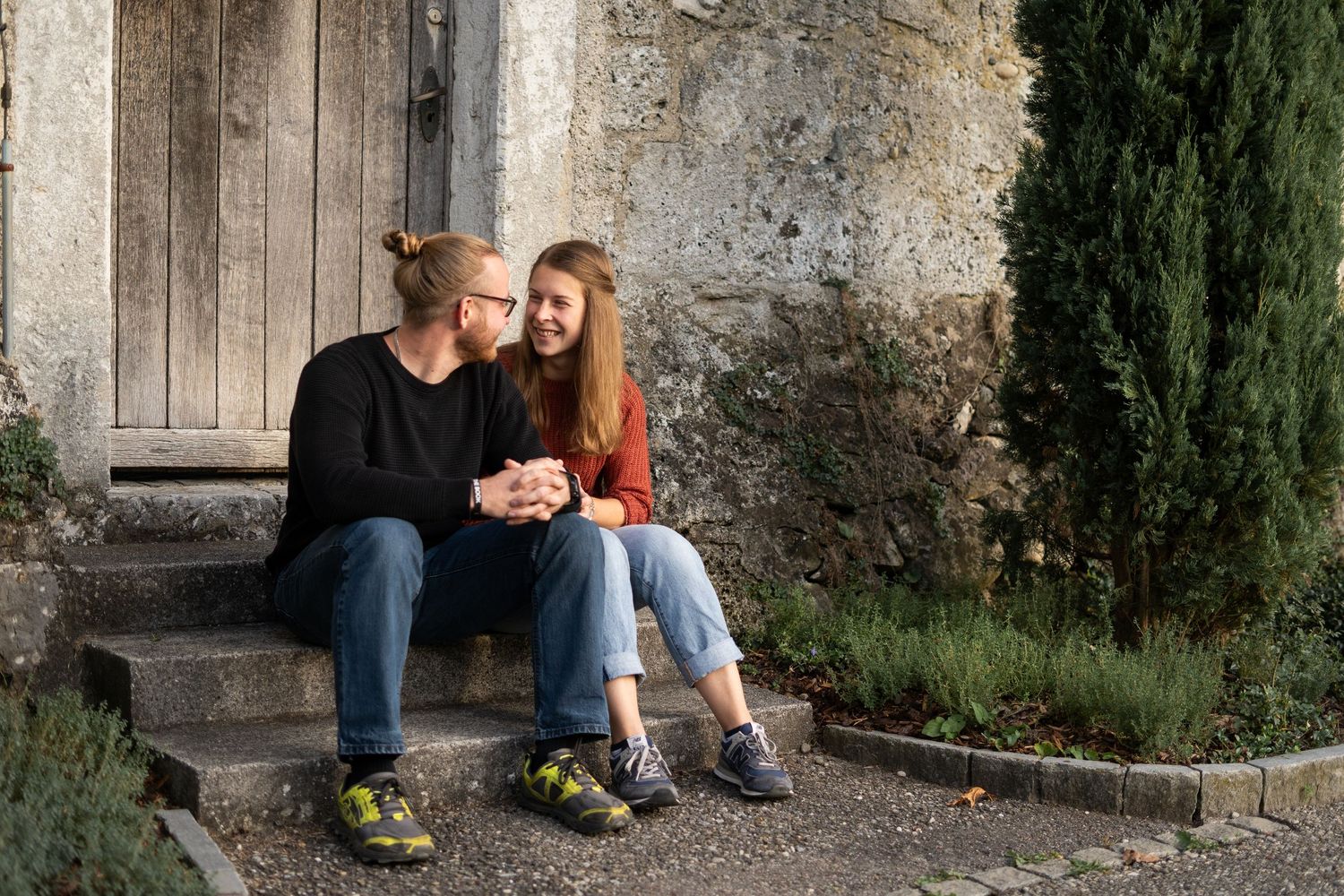 Romantic moment between couple on stone steps near old building.