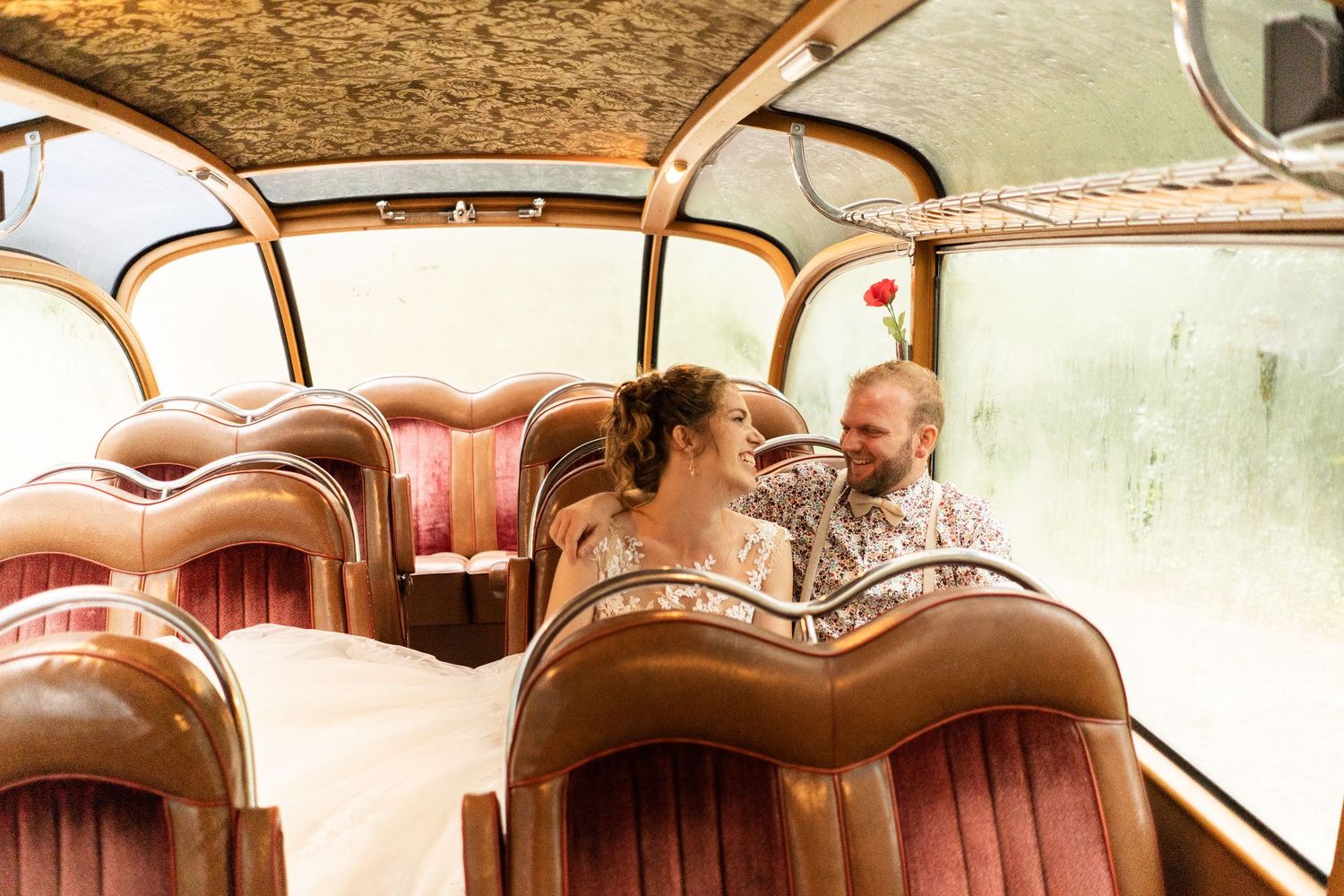 A couple shares an intimate moment inside a vintage bus with retro brown leather seating.