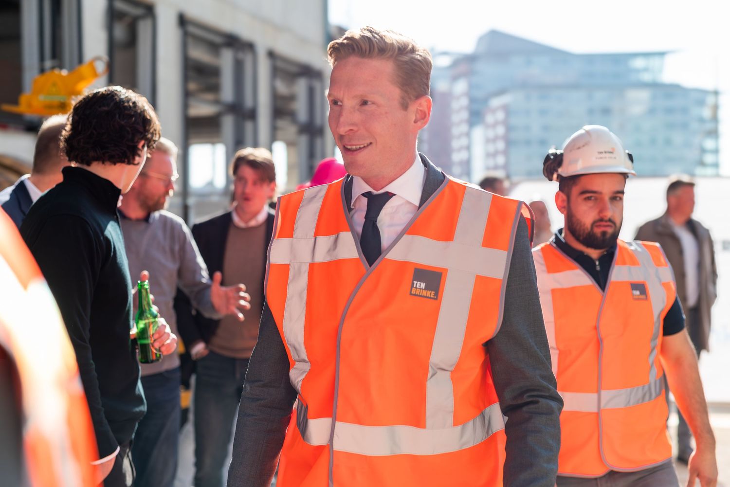 Workers in high-visibility safety vests walking outside a building. - Noelle Schmeltz Fotografie