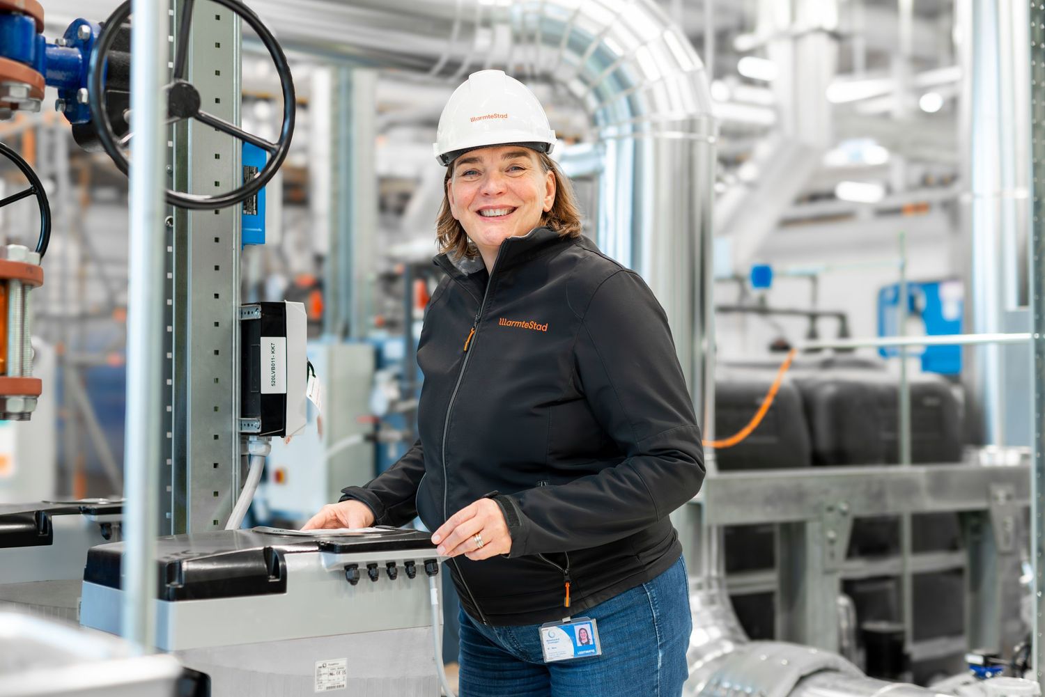 Industrial worker in safety gear operates machinery in a modern manufacturing facility.