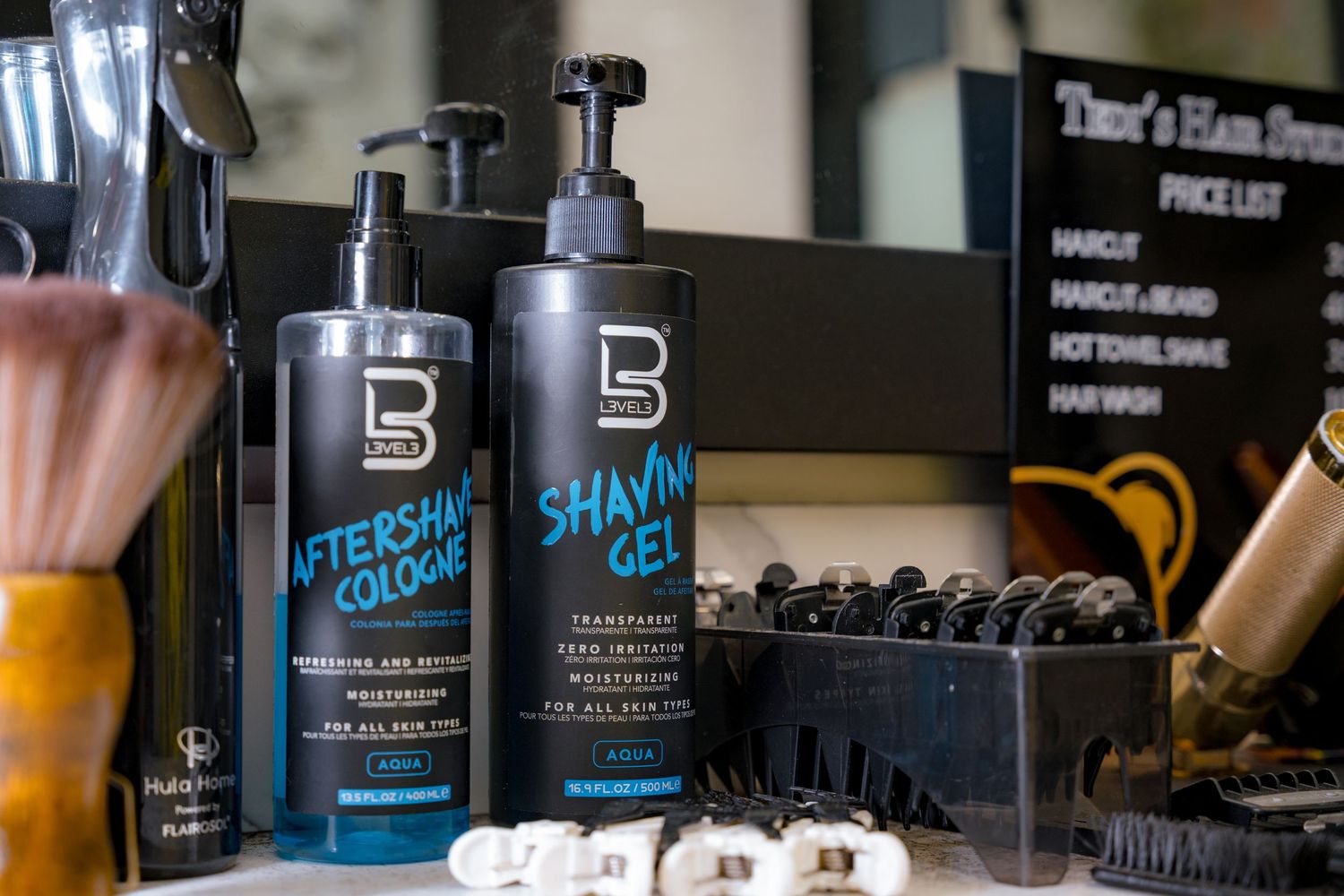 Black bottles of barbershop styling products and grooming supplies arranged on a counter.