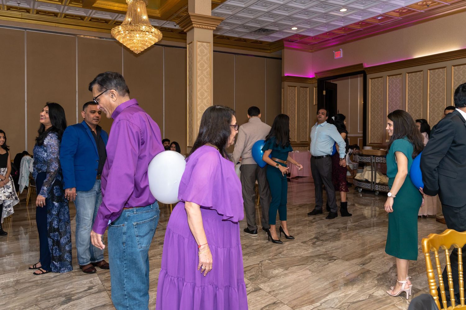 Event space with guests in formal attire mingling during a celebration.