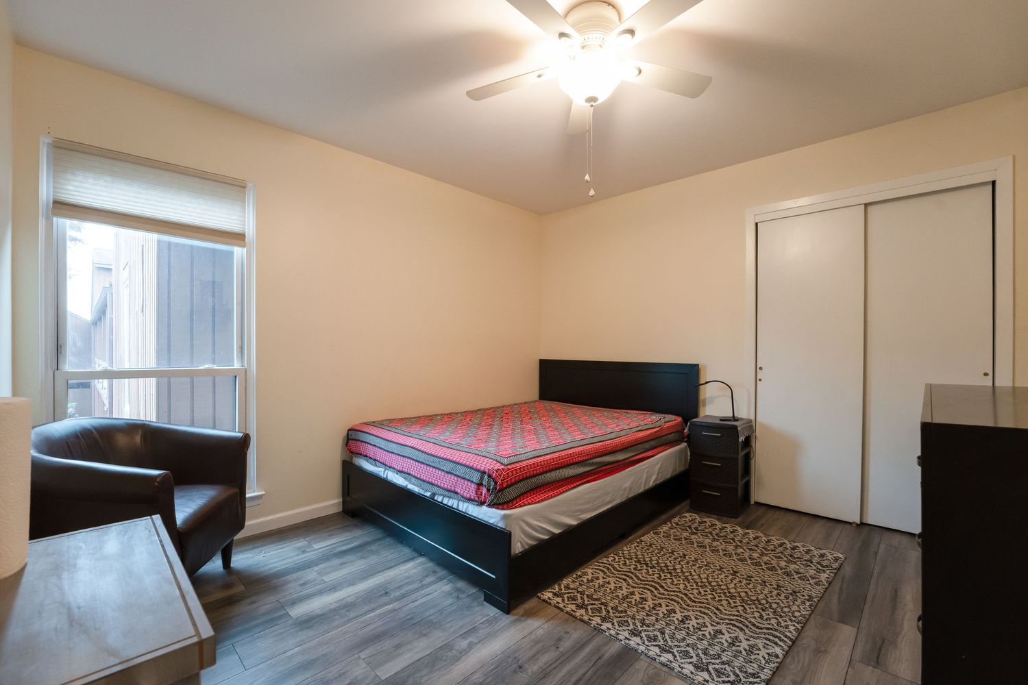 Bright modern bedroom with twin beds, beige walls, and hardwood flooring in a minimalist setting.