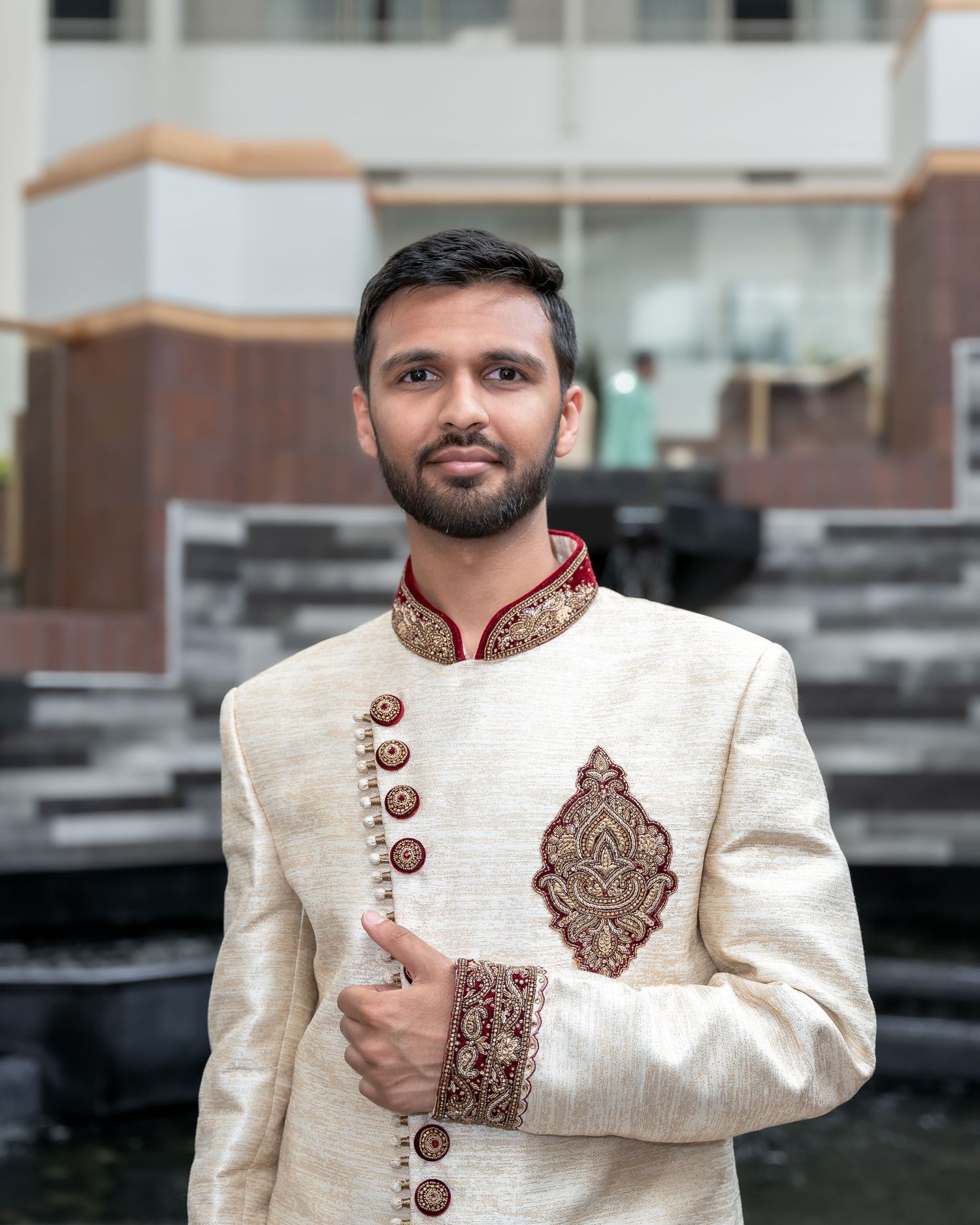 Wedding attire featuring an ivory sherwani with embroidered details and decorative buttons.