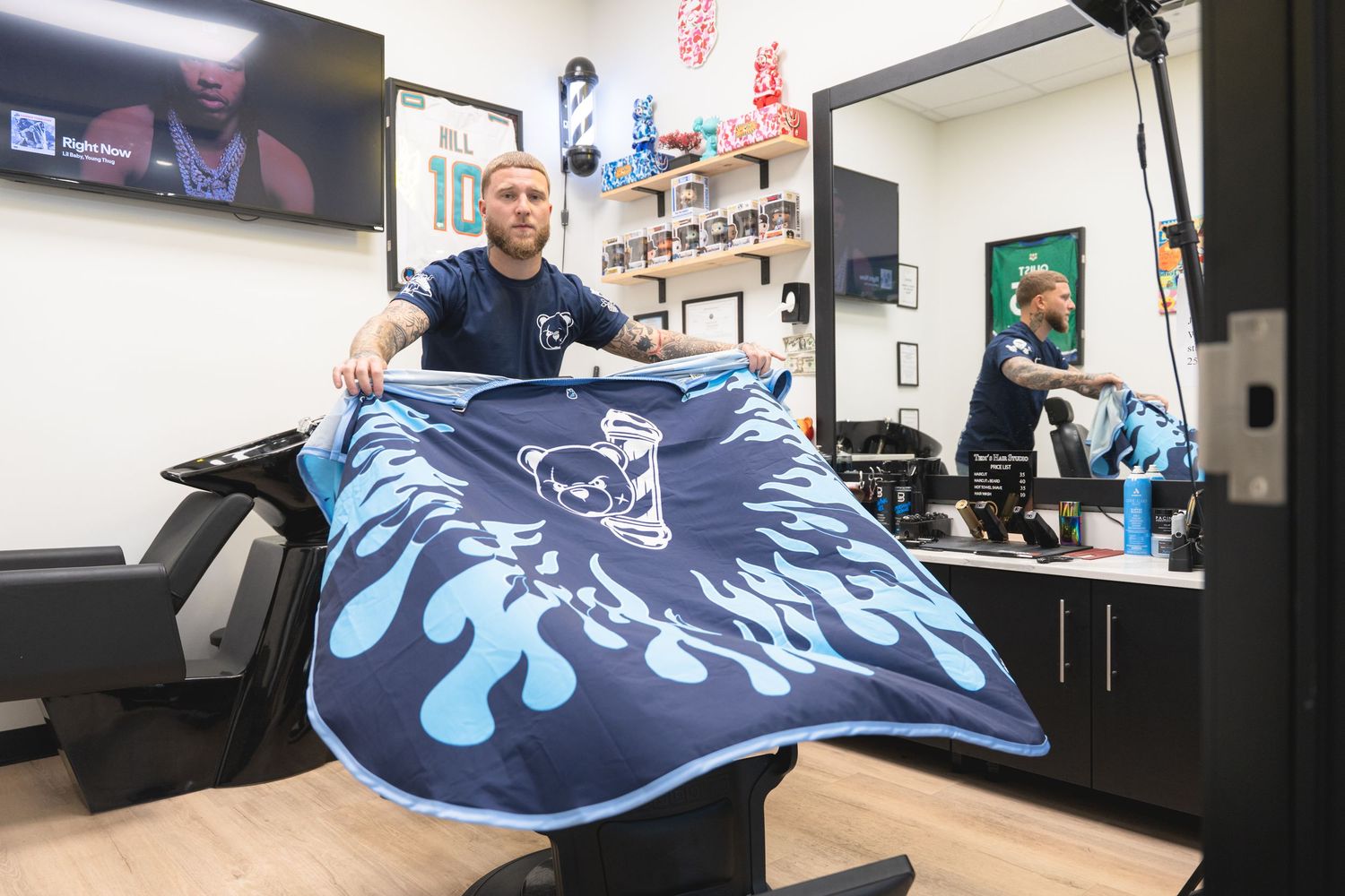 Navy blue t-shirt with bear logo and flame design being showcased in store display.